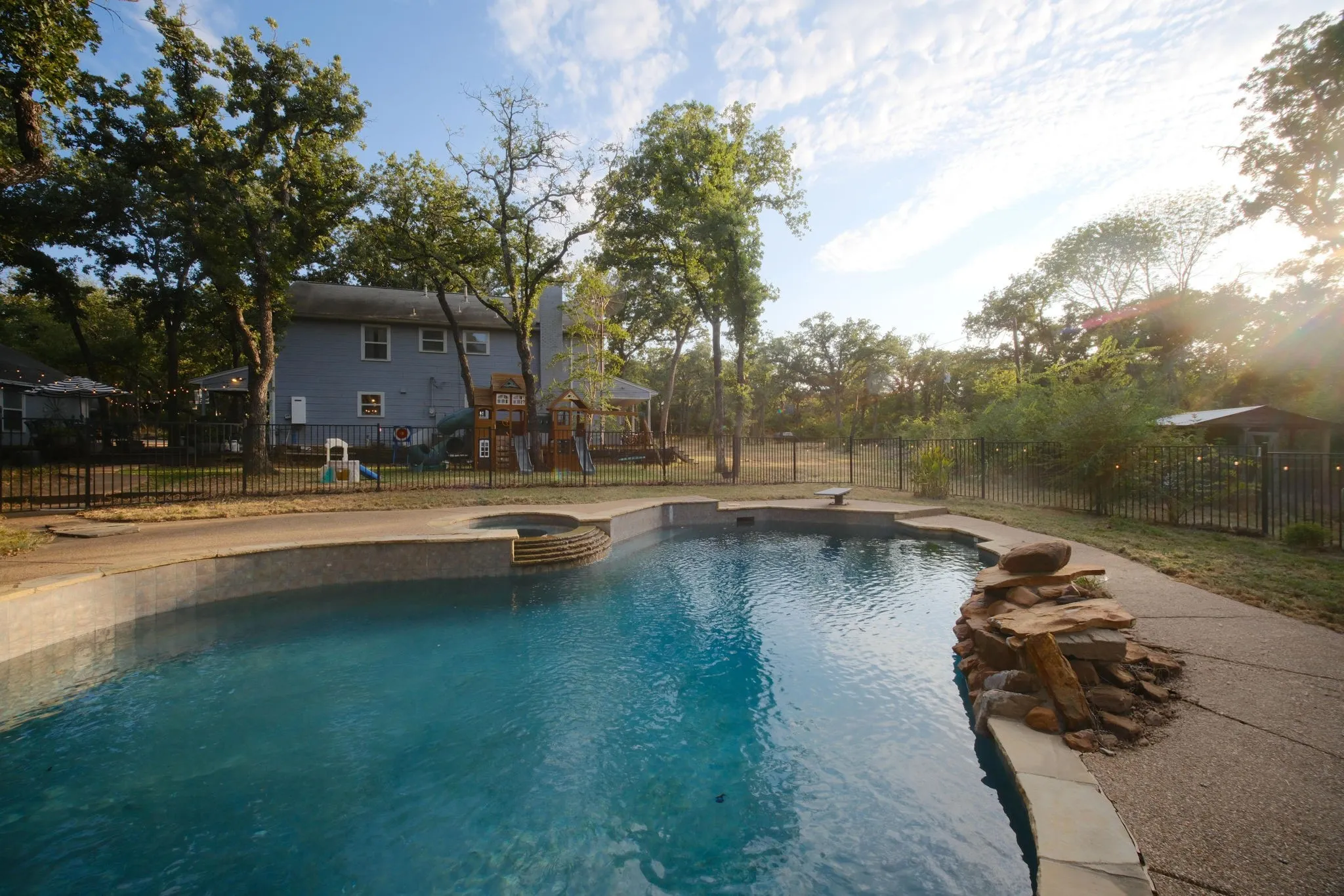 Swimming pool with integrated spa and stone coping