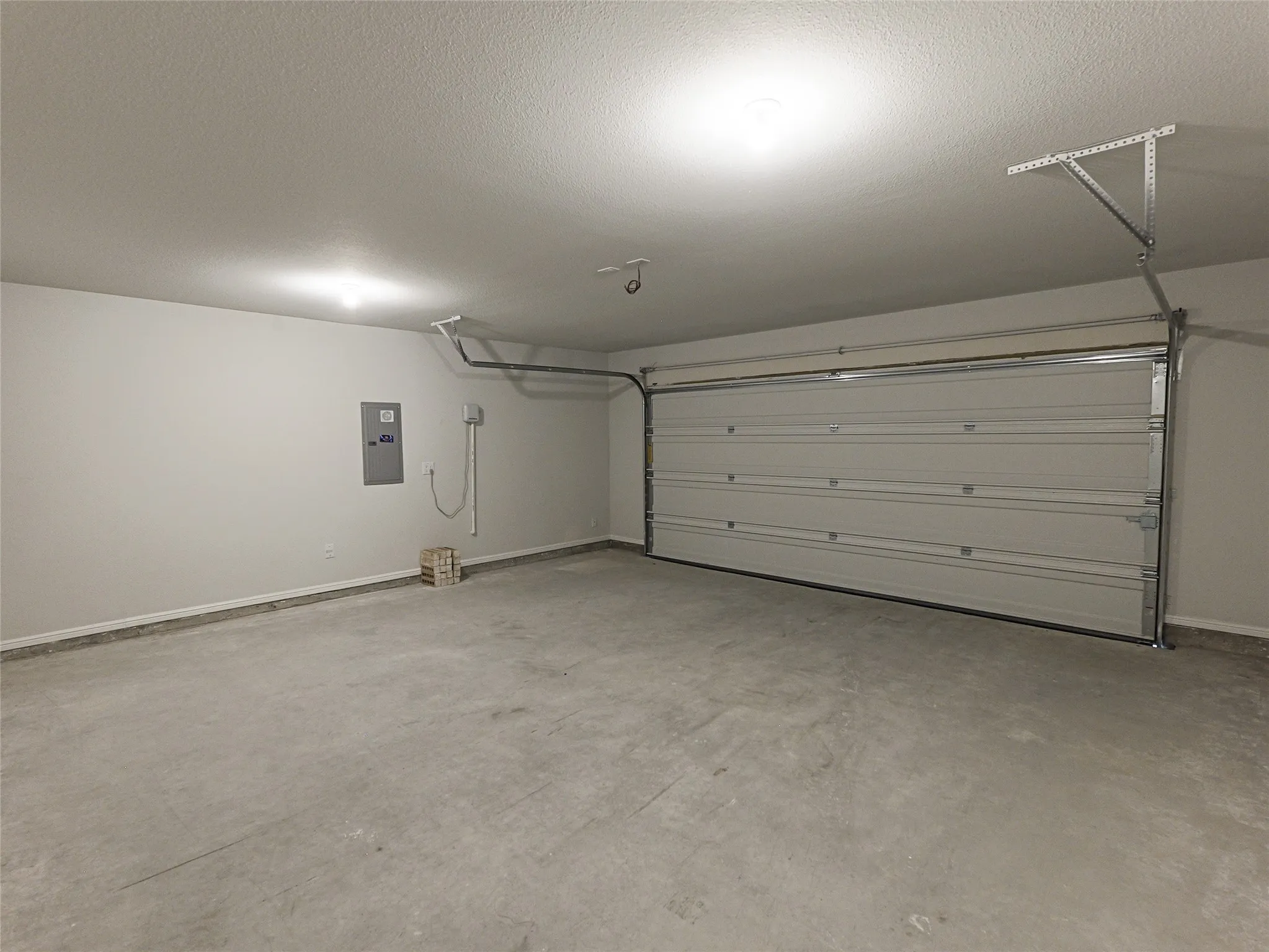 Spacious garage with a concrete floor, painted walls, and an overhead garage door