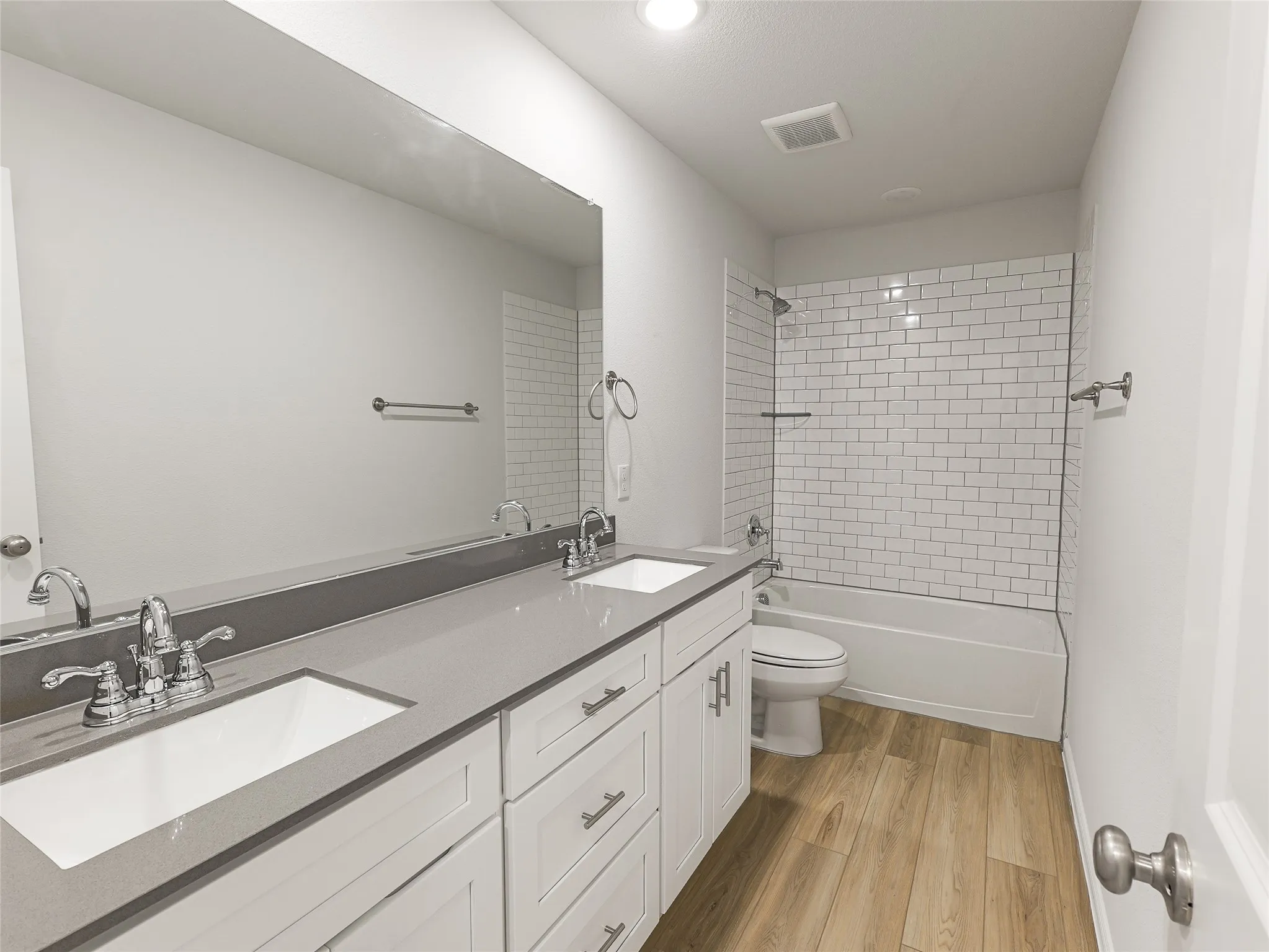 Dual vanity with undermount sinks, stone countertops, and chrome fixtures