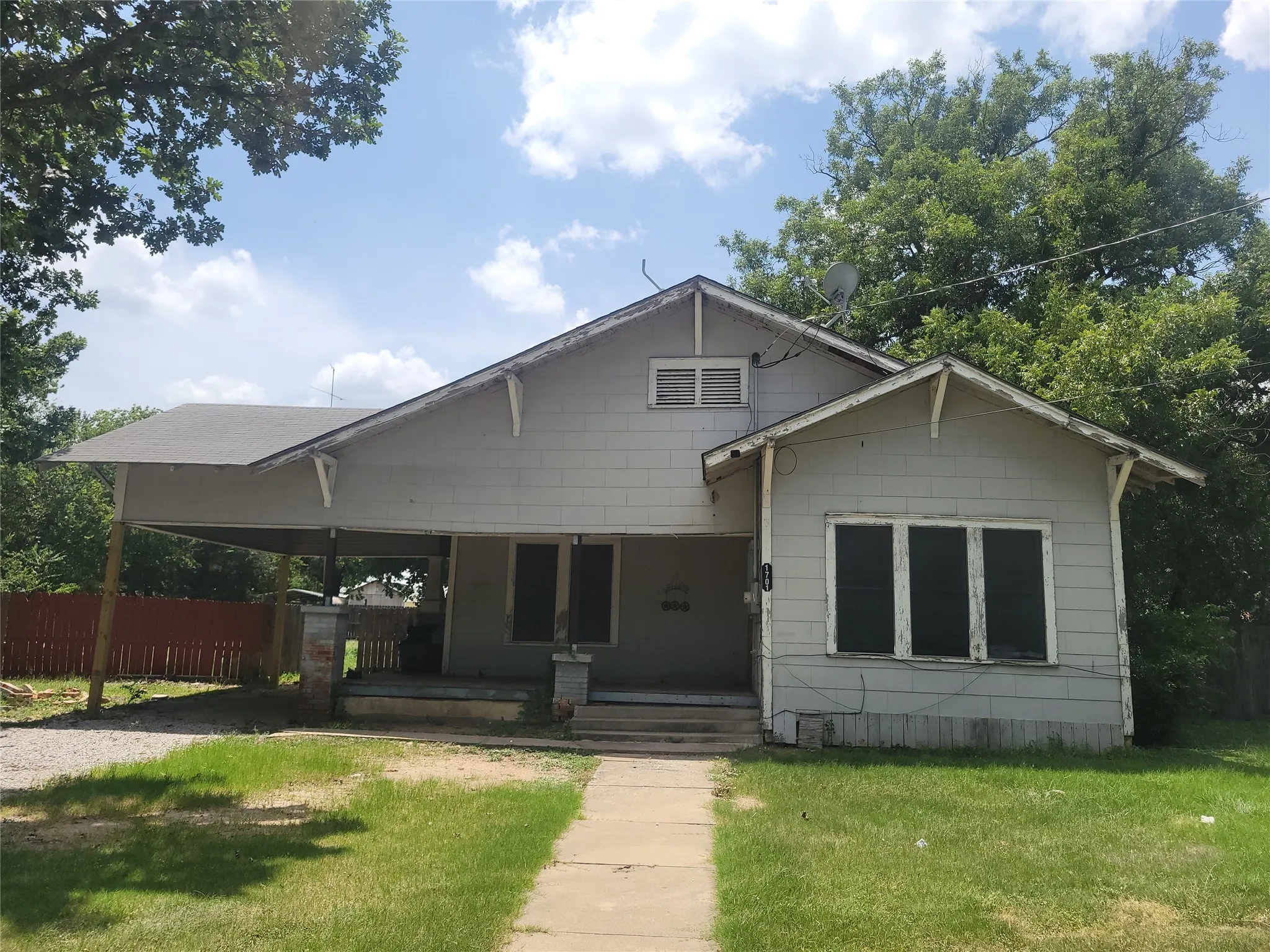 Single-story residence featuring light gray siding and a covered front porch