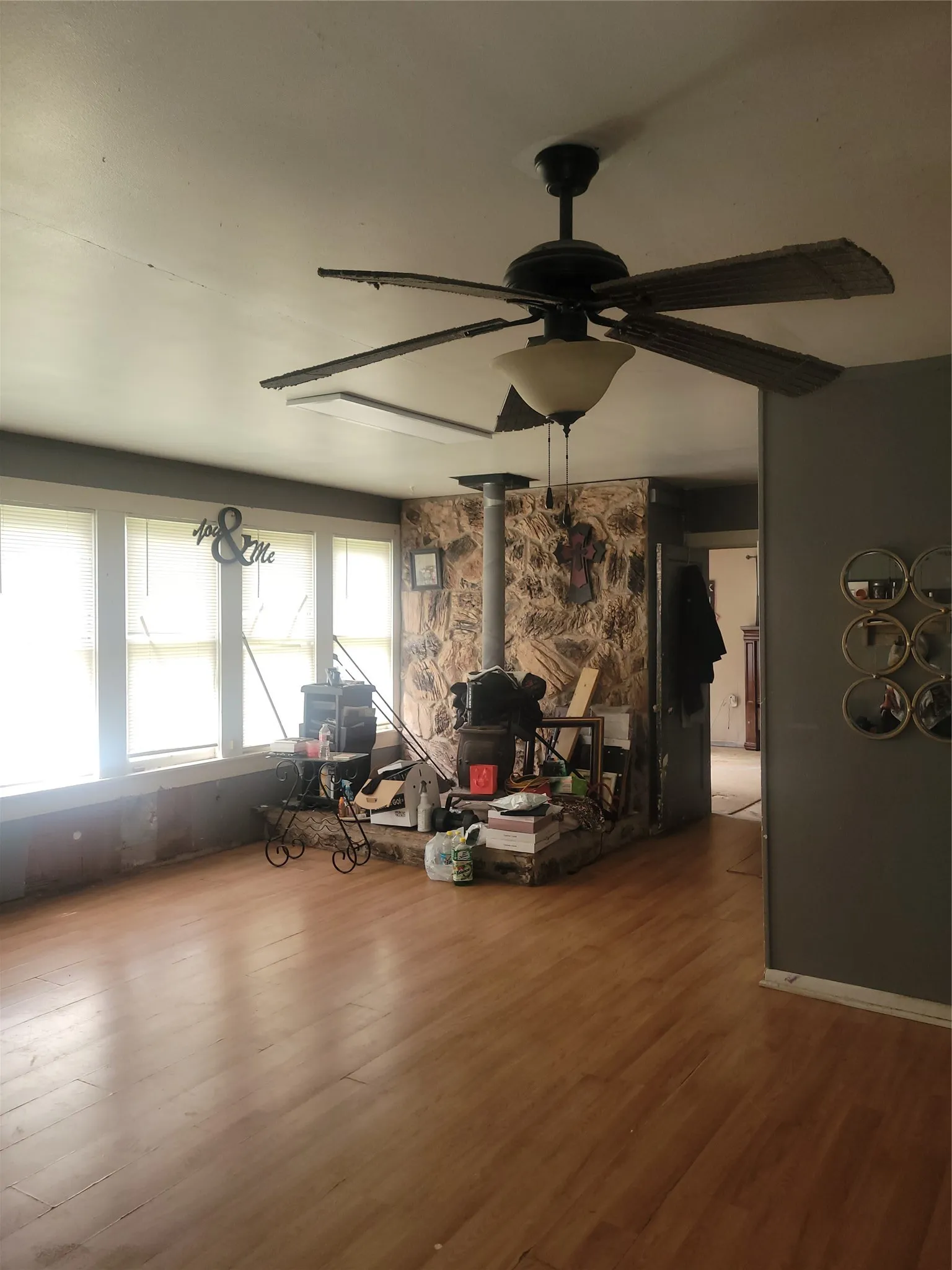 Spacious interior featuring wood-finish flooring, a stone-clad fireplace, and multiple windows