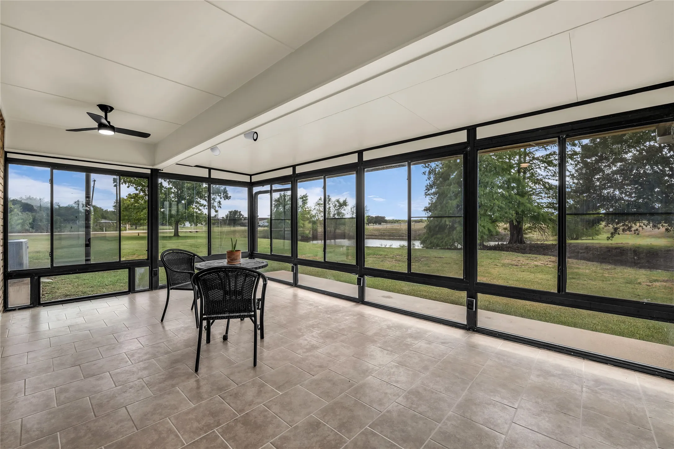Screened porch completely closes off to become a 4 seasons room for year-round use. It has a beautiful view of the pond and pasture.