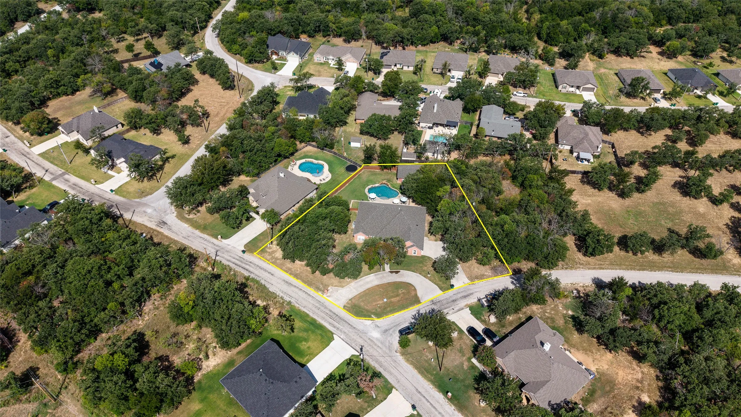 Expansive property featuring a private swimming pool, mature trees, and a circular driveway