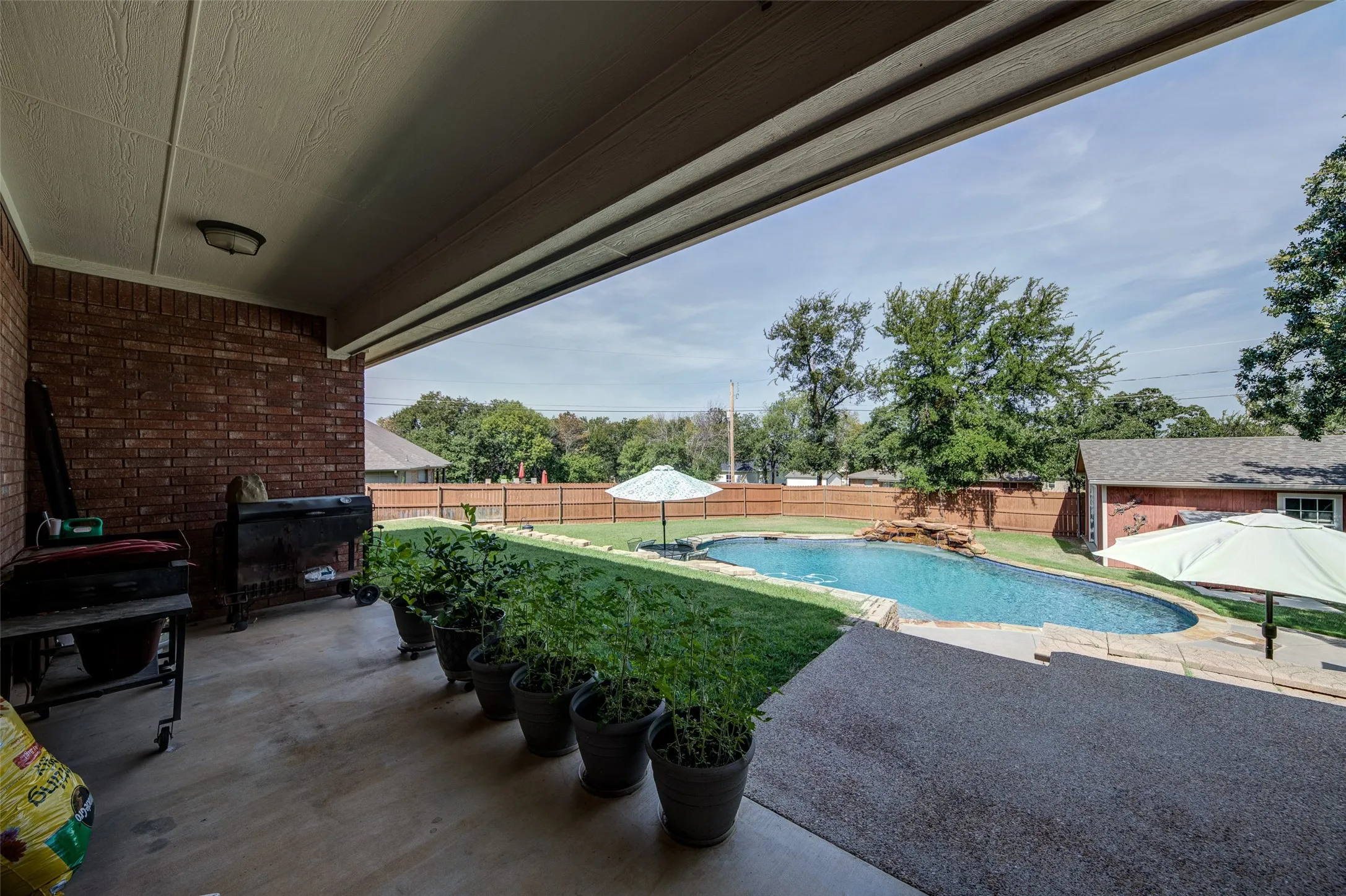 Covered patio with brick wall and concrete flooring