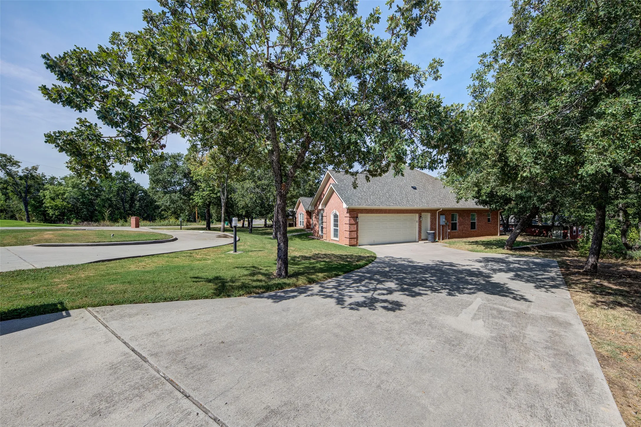 Brick exterior with a gray shingle roof and white garage door