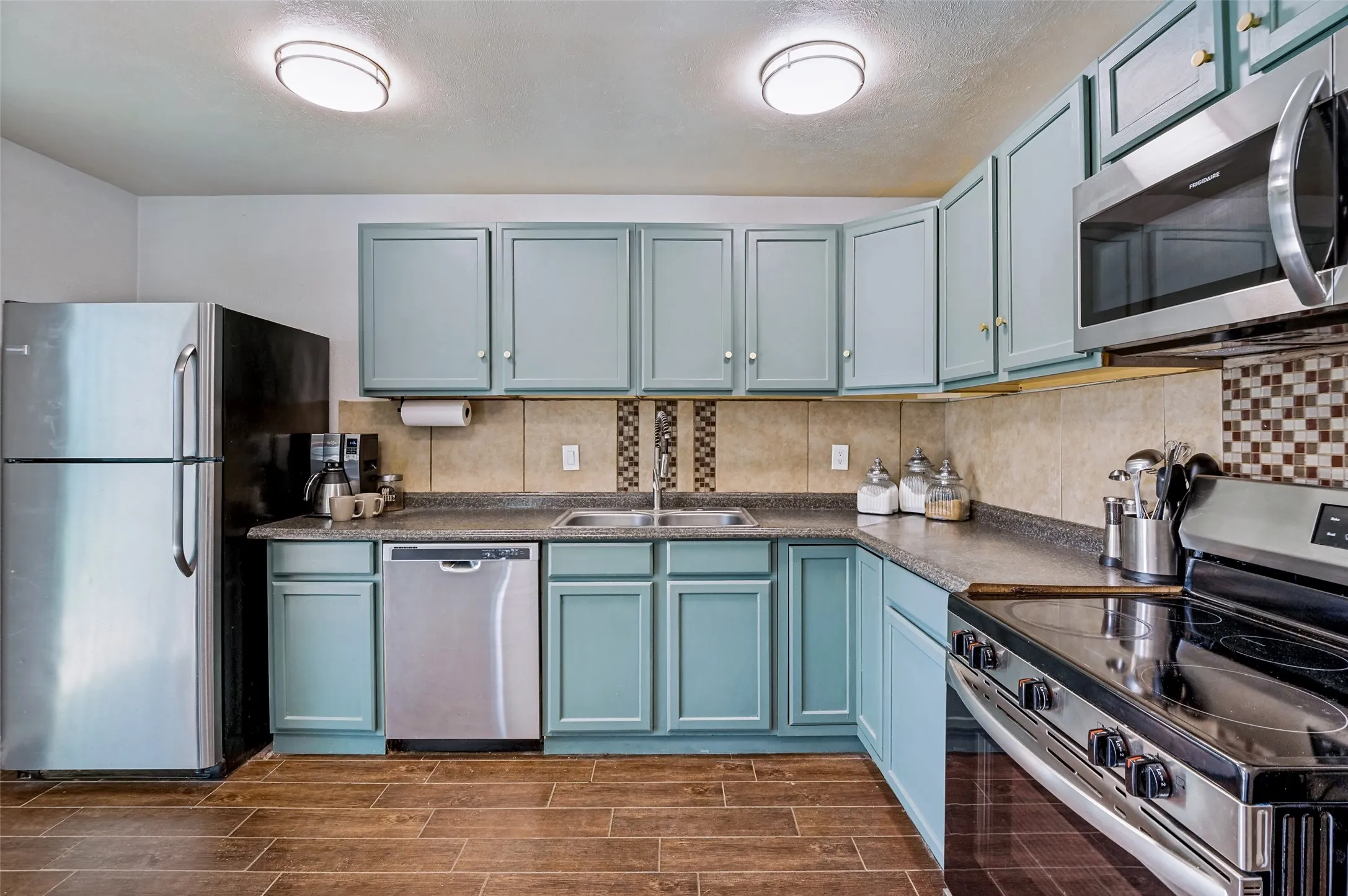 Tile backsplash and custom color cabinetry make the kitchen inviting.