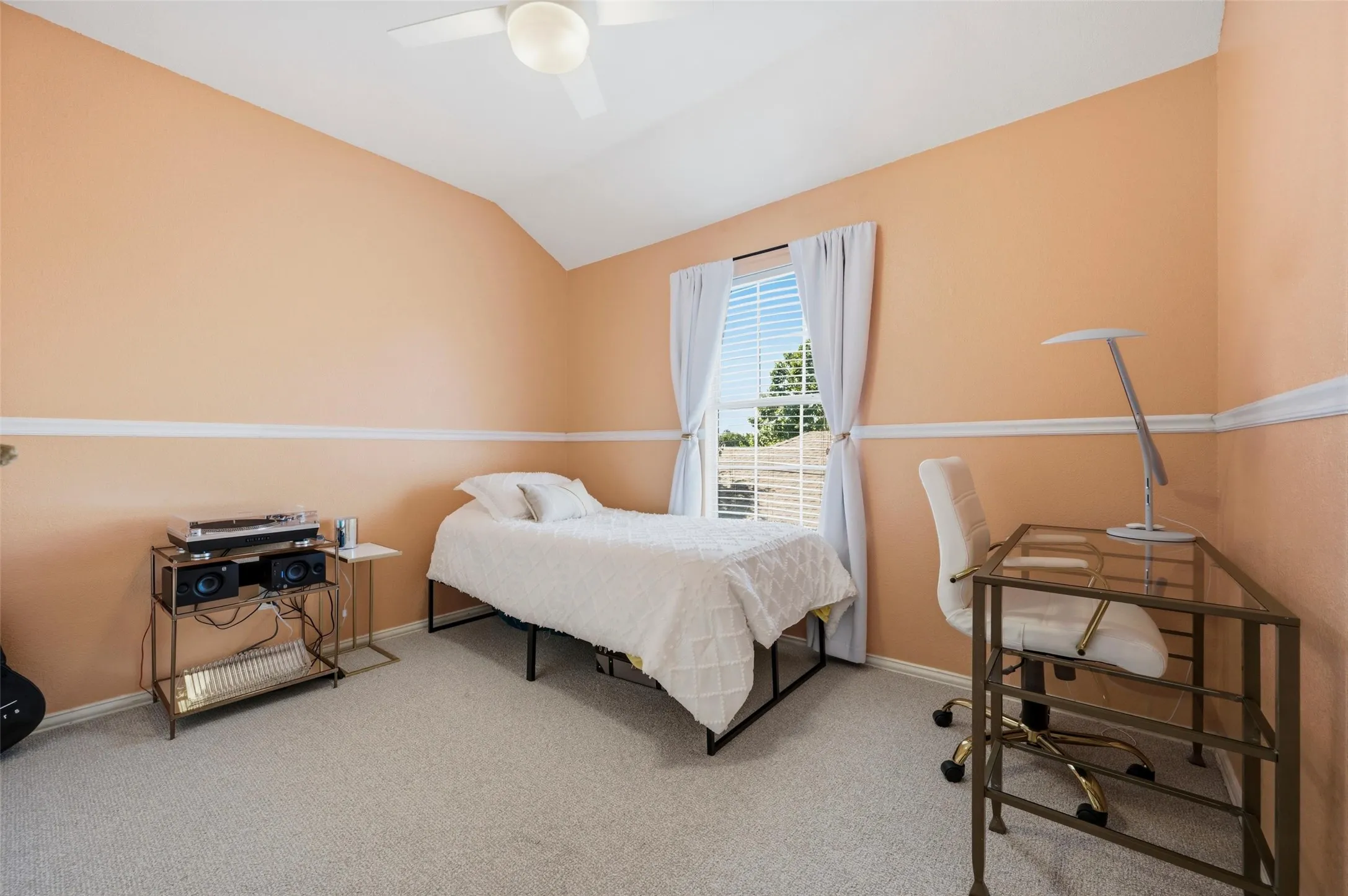 Vaulted ceiling with ceiling fan, wall trim detailing, and a window with blinds