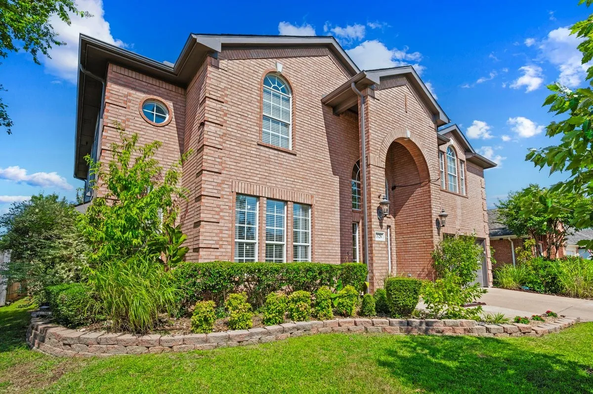 Brick exterior featuring an arched portico, multiple arched windows, and a round accent window