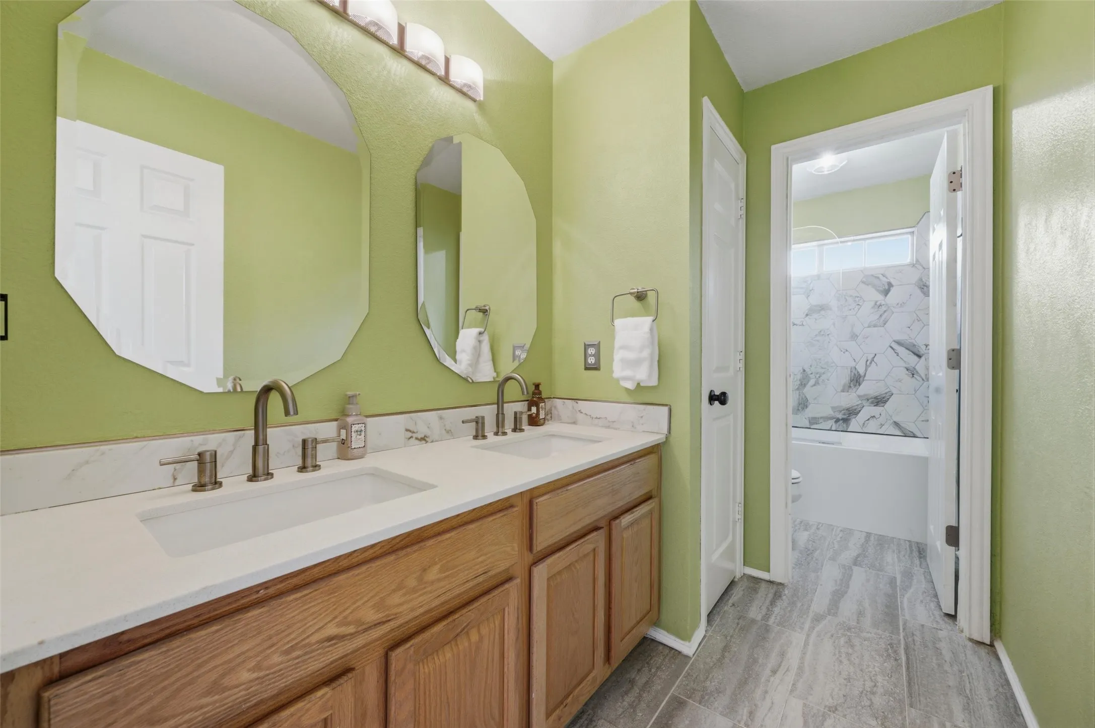 Dual undermount sinks set in a stone-finish countertop with wood-finish cabinetry