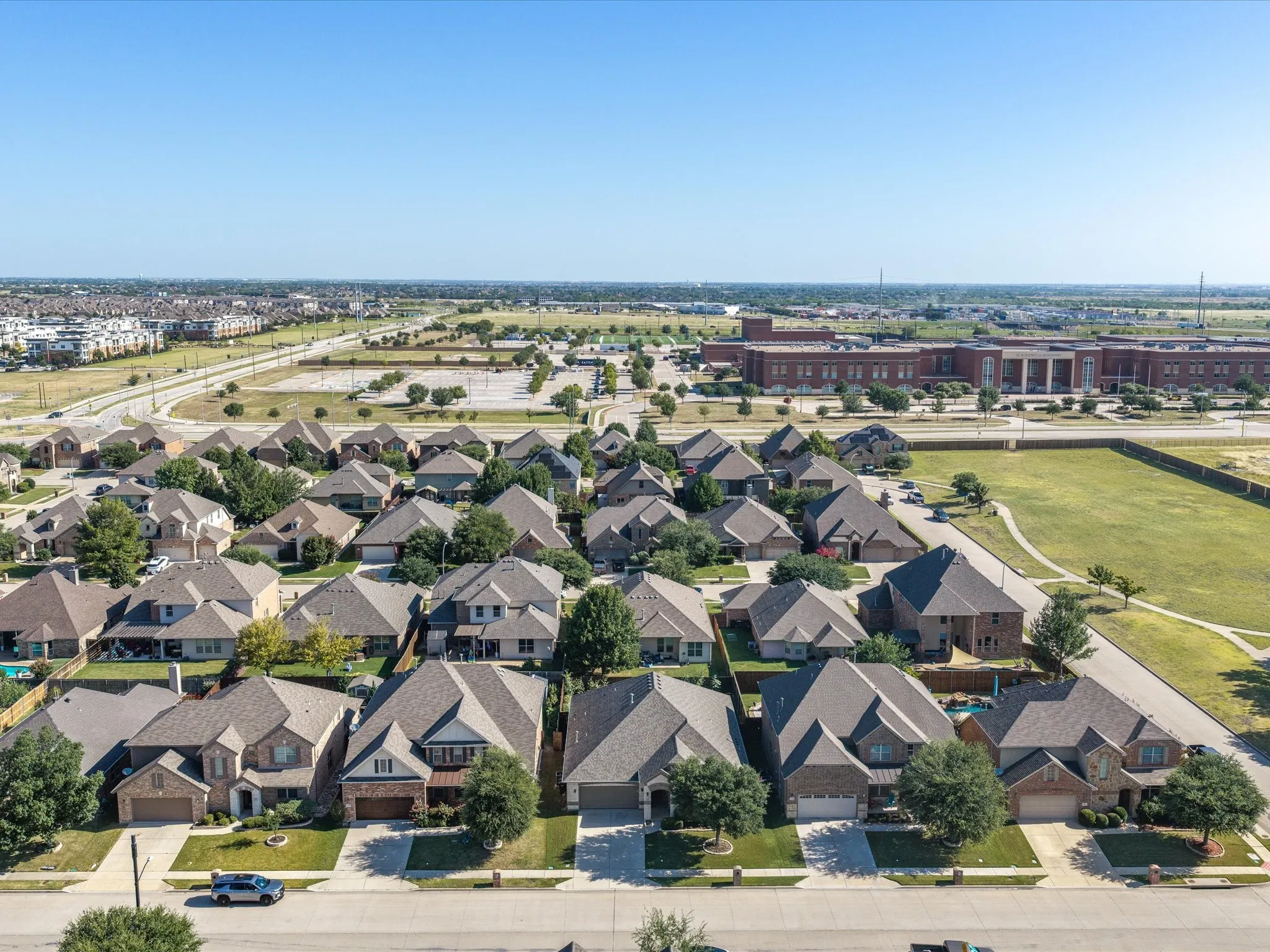 Residential neighborhood with varied architectural styles, mature landscaping, and an adjacent community building