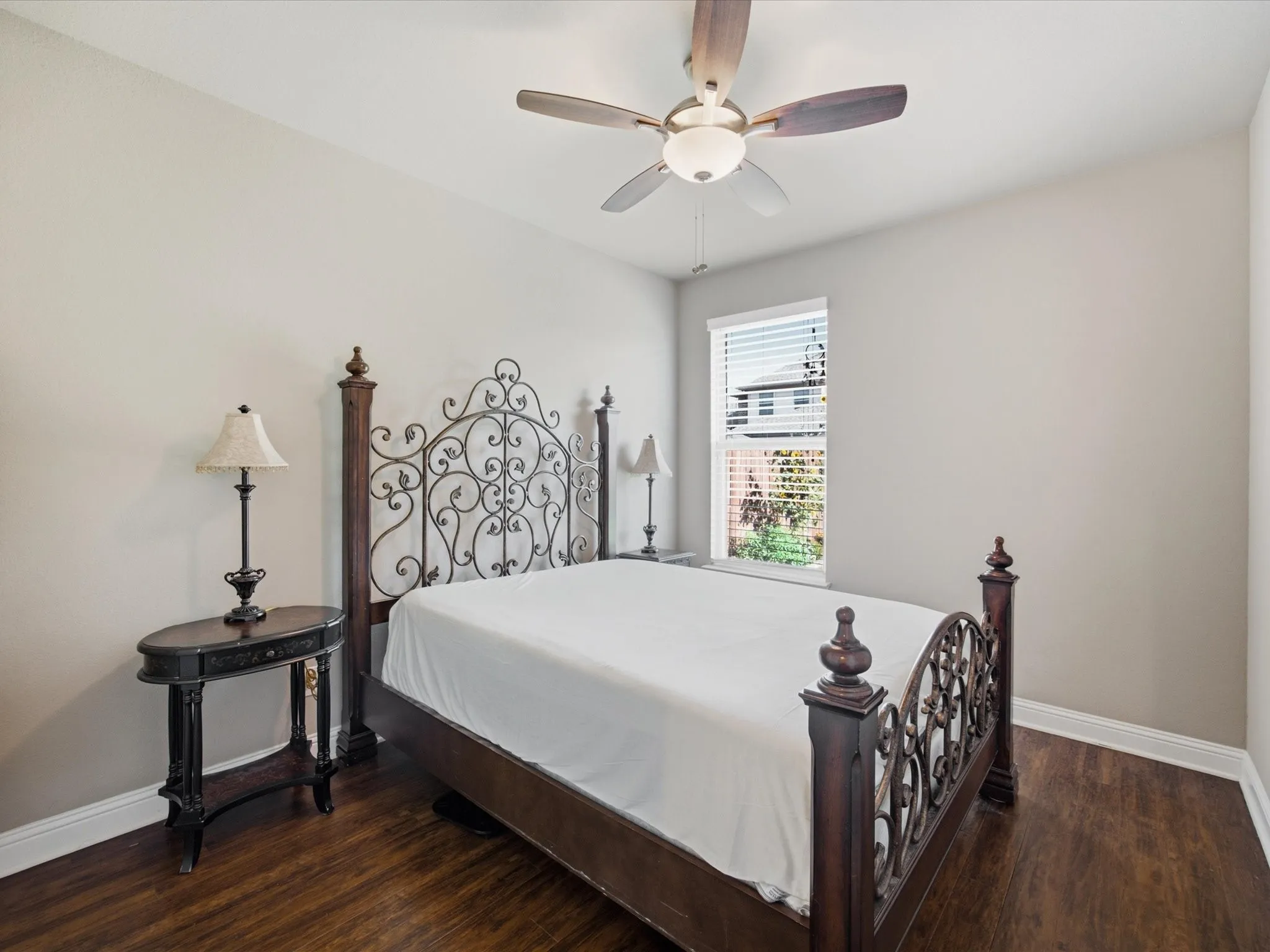 Recessed window with blinds, wood-finish flooring, and a ceiling fan with integrated lighting