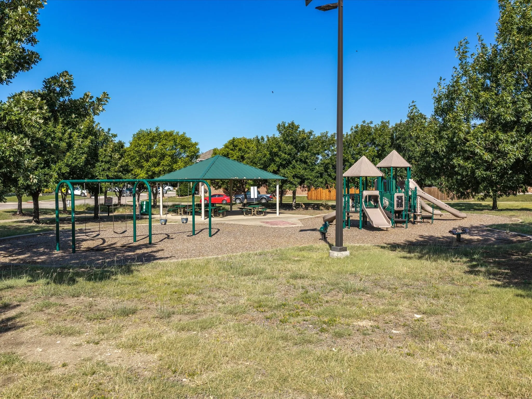 Community park featuring a covered picnic area, swings, and a play structure