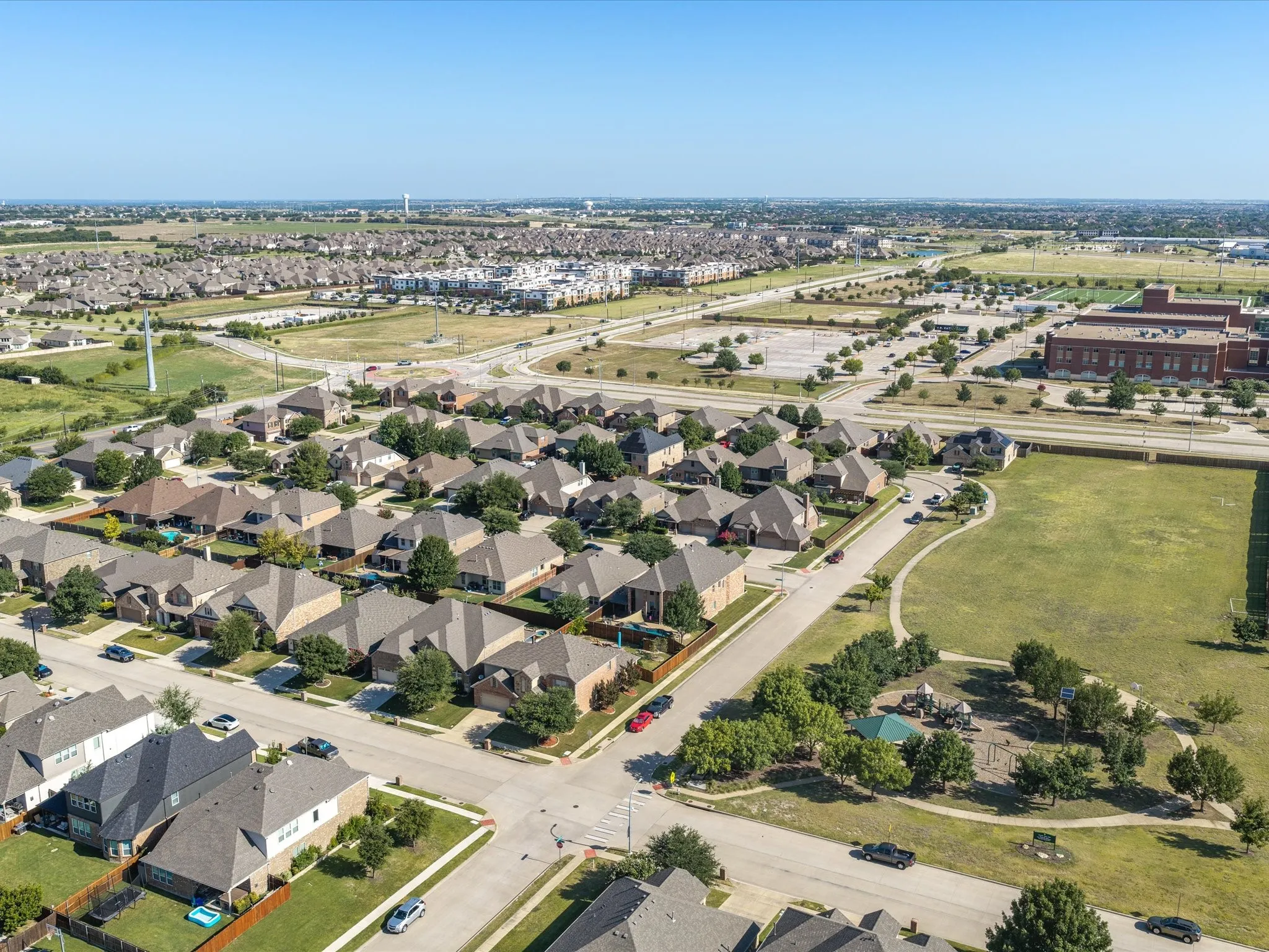 Residential neighborhood featuring a community park with playground equipment and a central open field
