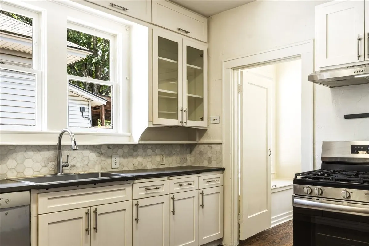 Kitchen with marble countertops, gas range.