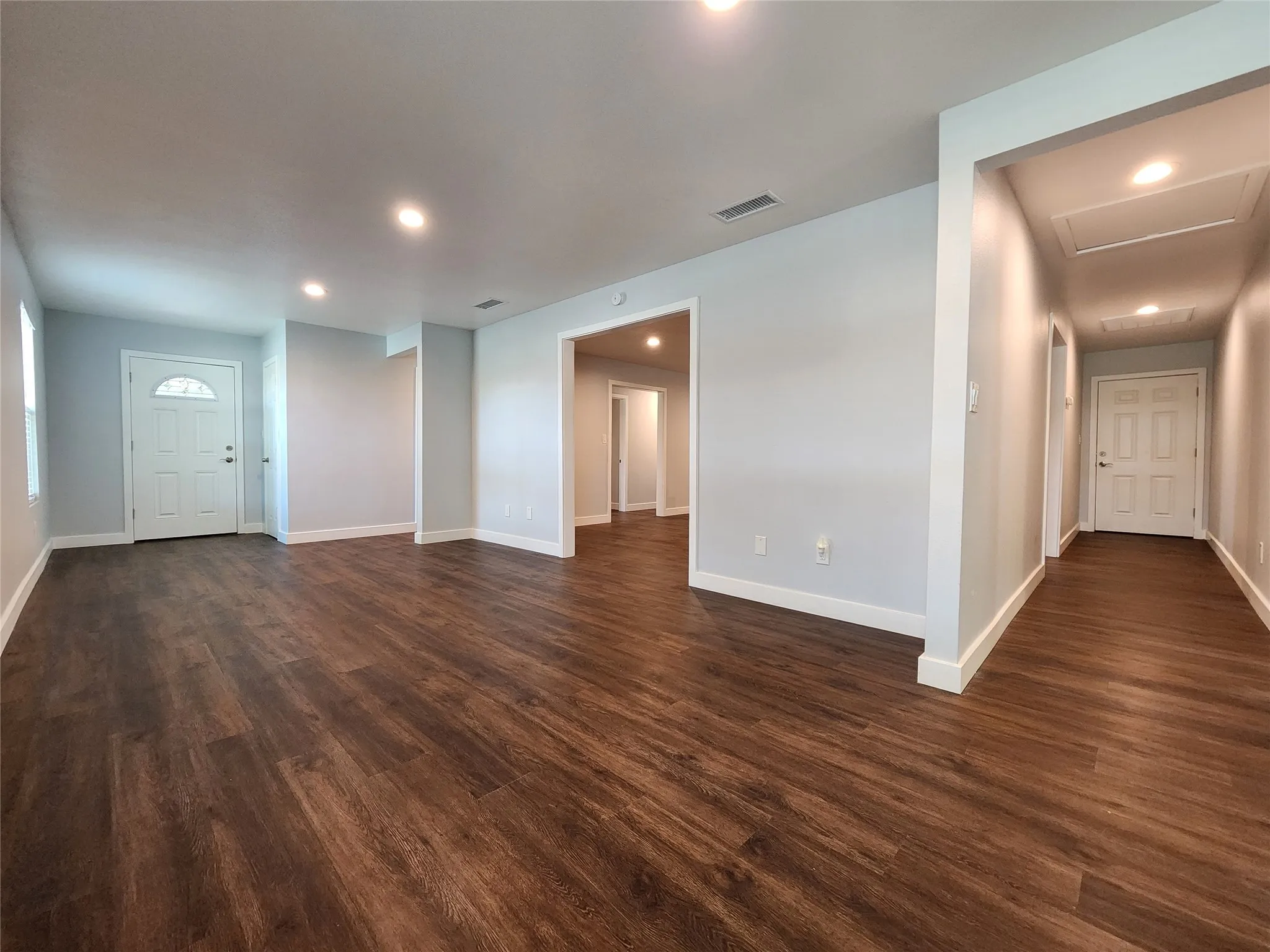 Living room with hallway leading to the back door.