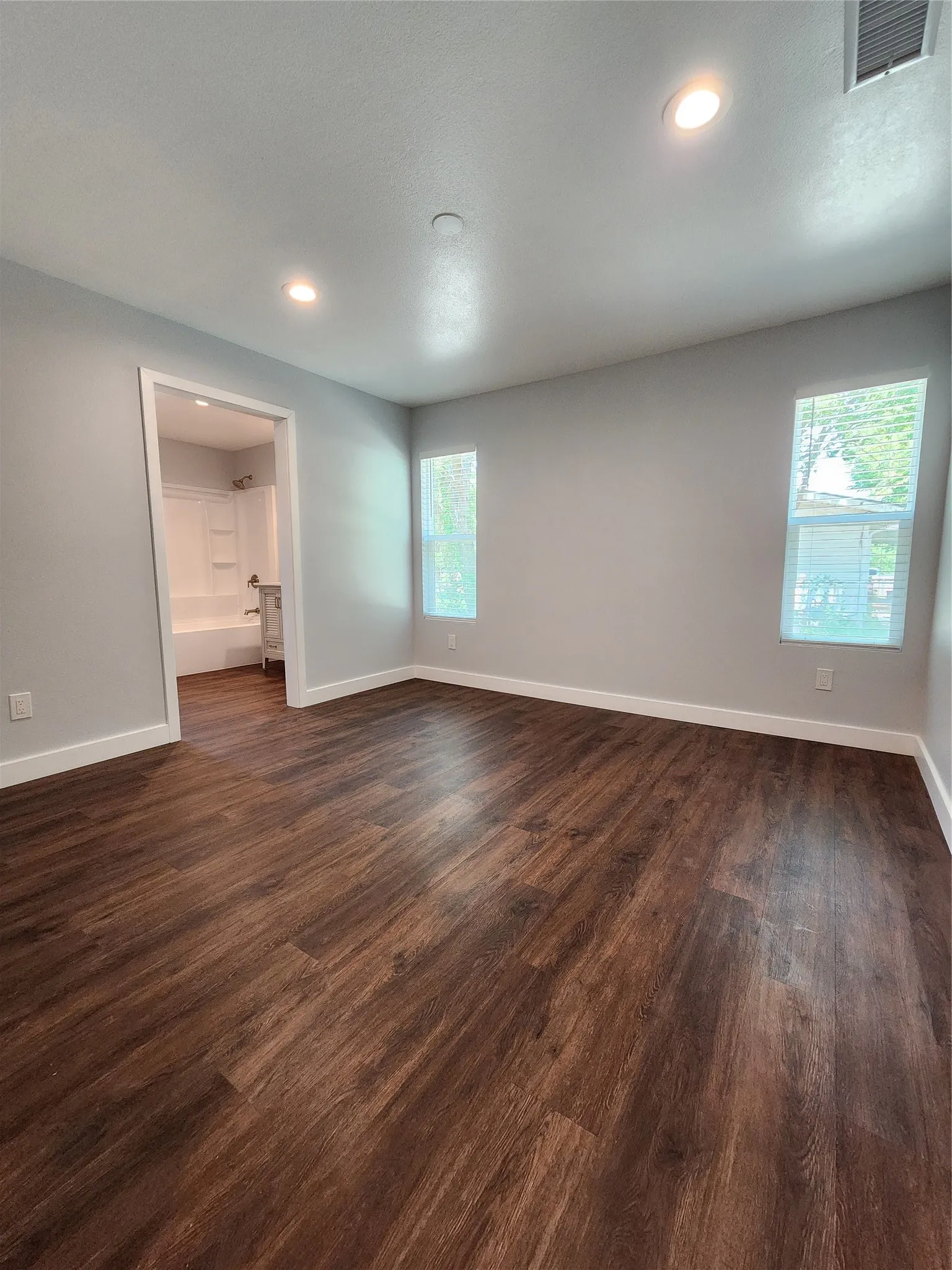 Wood-finish flooring throughout, recessed lighting, and dual windows with natural light.