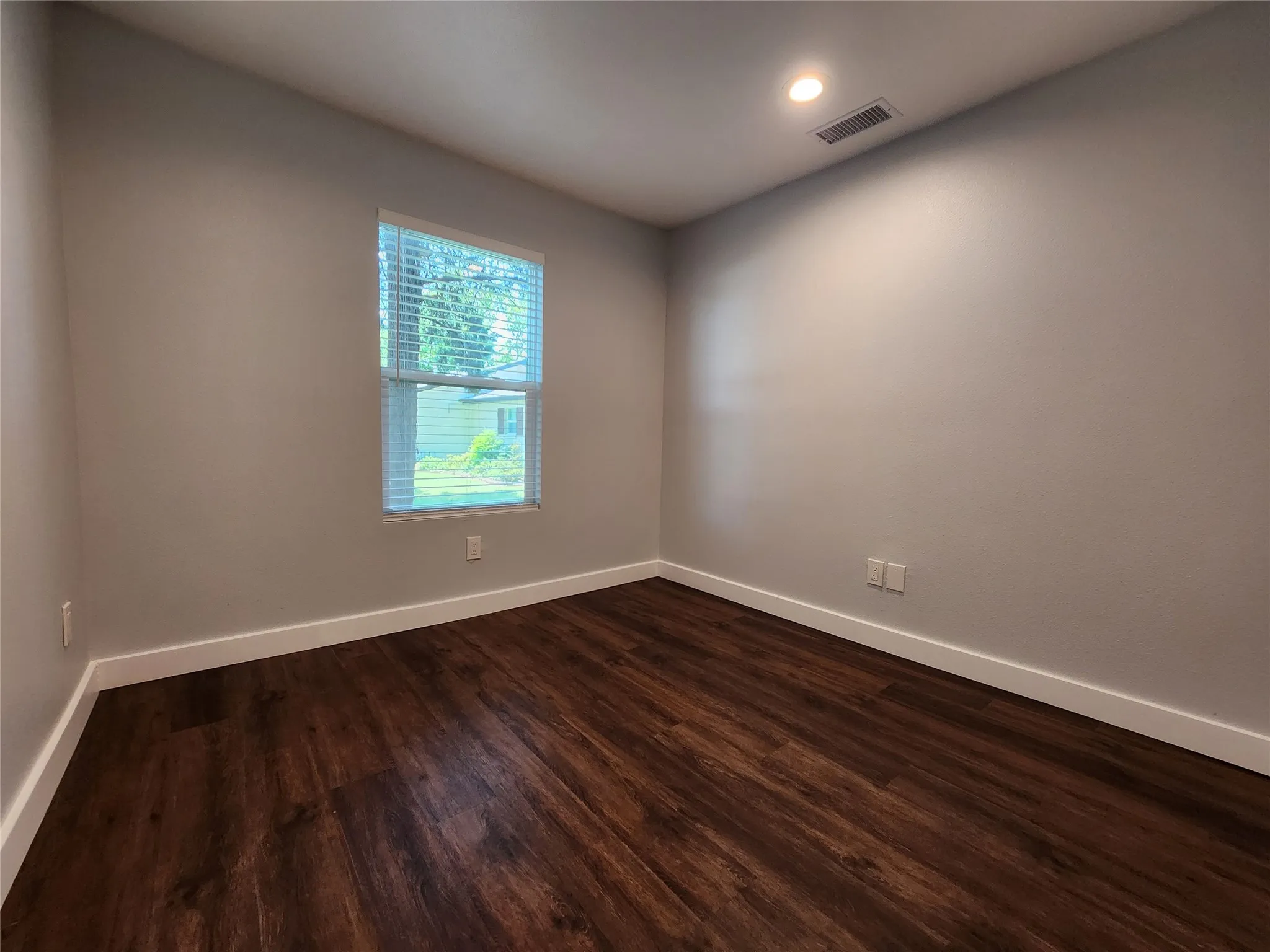 Wood-finish flooring, recessed lighting, and a window with horizontal blinds