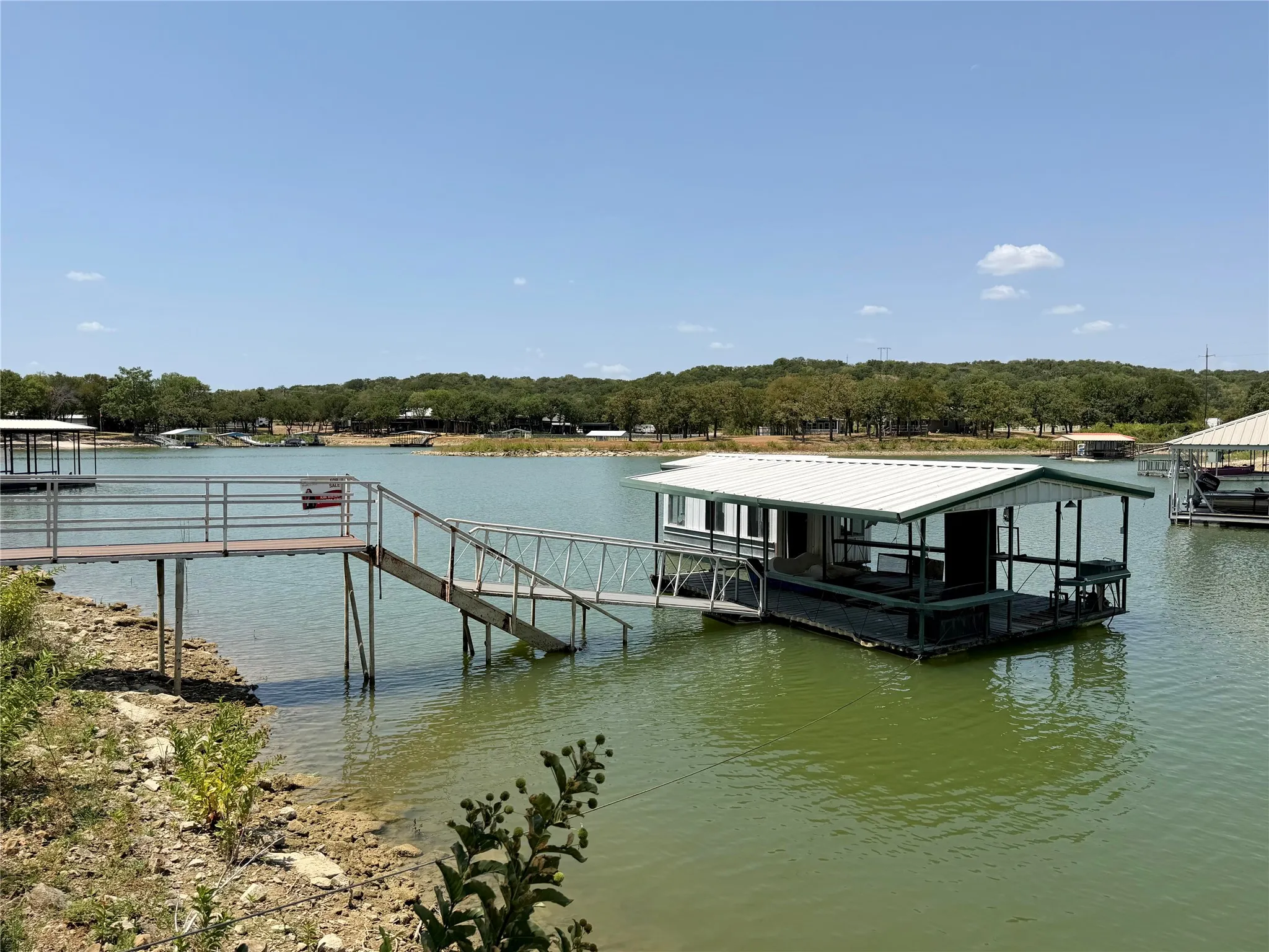 Floating boat house with a covered deck, metal roof, and direct access from a private dock