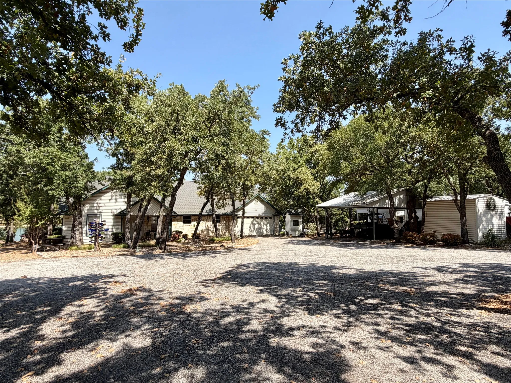Vaulted ceiling, stone-clad fireplace, arched transom window, ceiling fan, and tile flooring