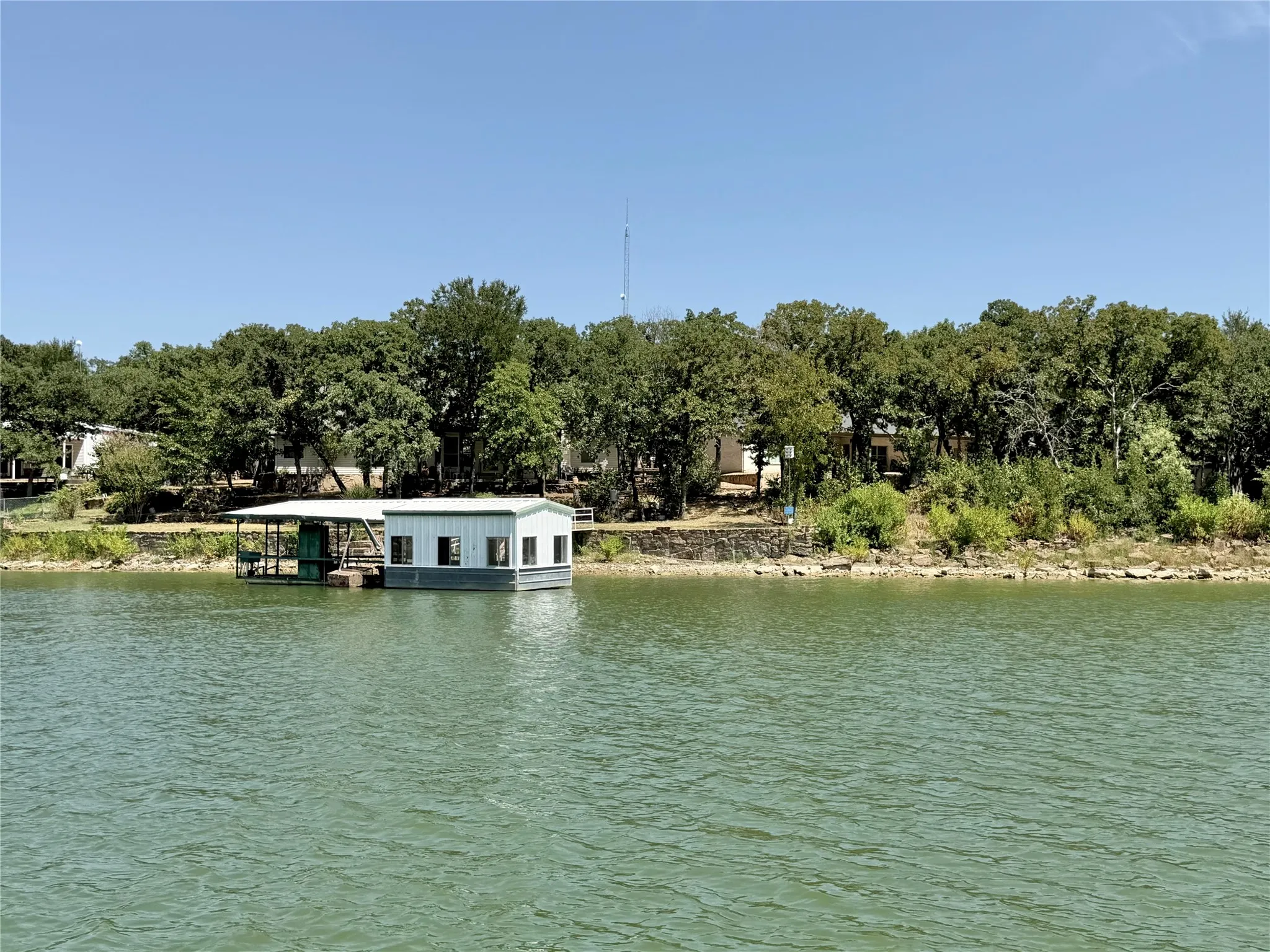 Waterfront property with a private boat dock featuring a covered slip and enclosed storage