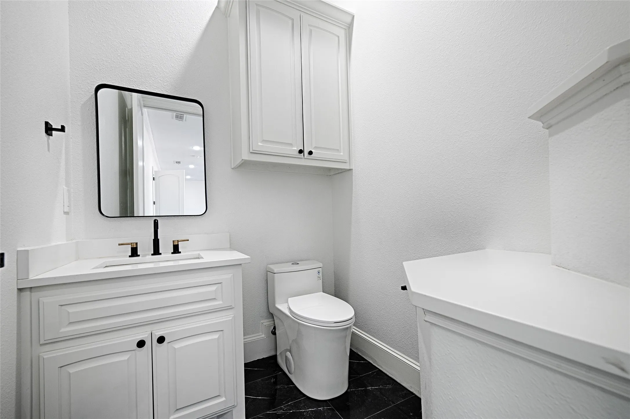 Bathroom with baseboards, vanity, and toilet
