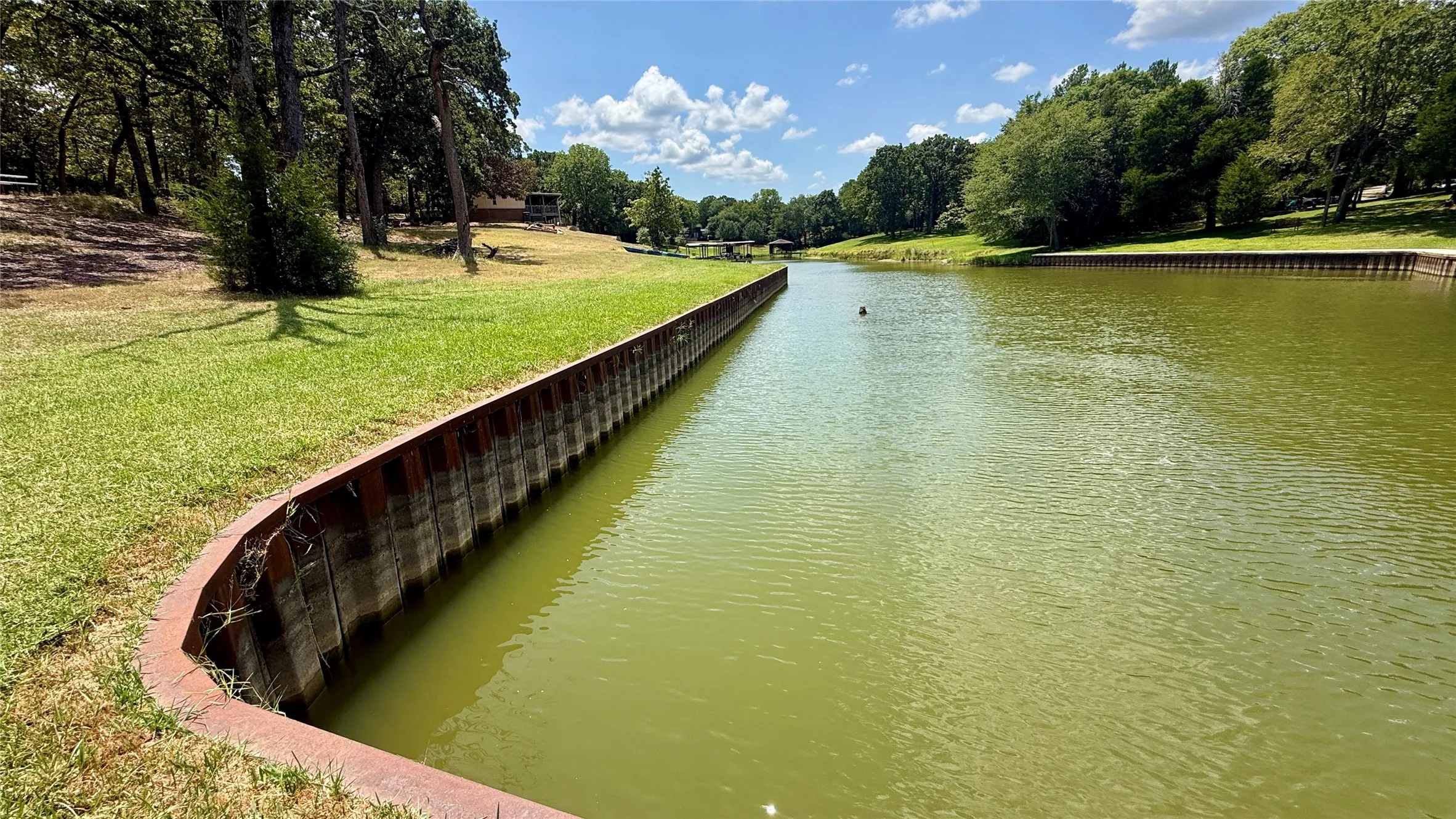 Curving steel retaining wall defines the protected waterfront shoreline of this Richland Chambers Lake property in Streetman, Texas.