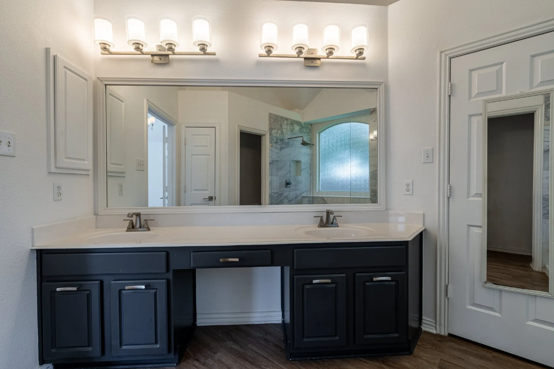 Dual vanity with integrated sinks, dark wood-finish cabinetry, and a large wall-mounted mirror