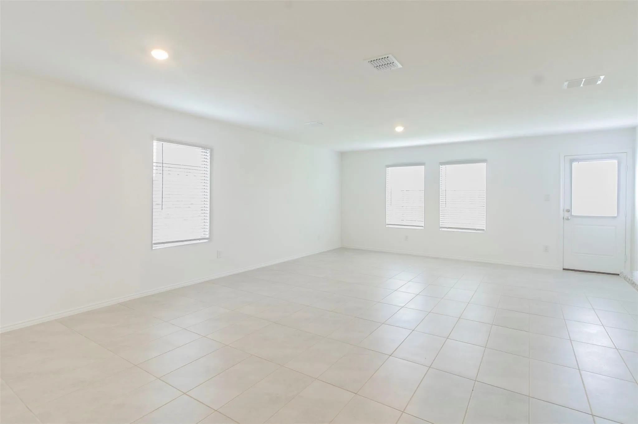 Open-concept living area with neutral wall tones and recessed lighting
