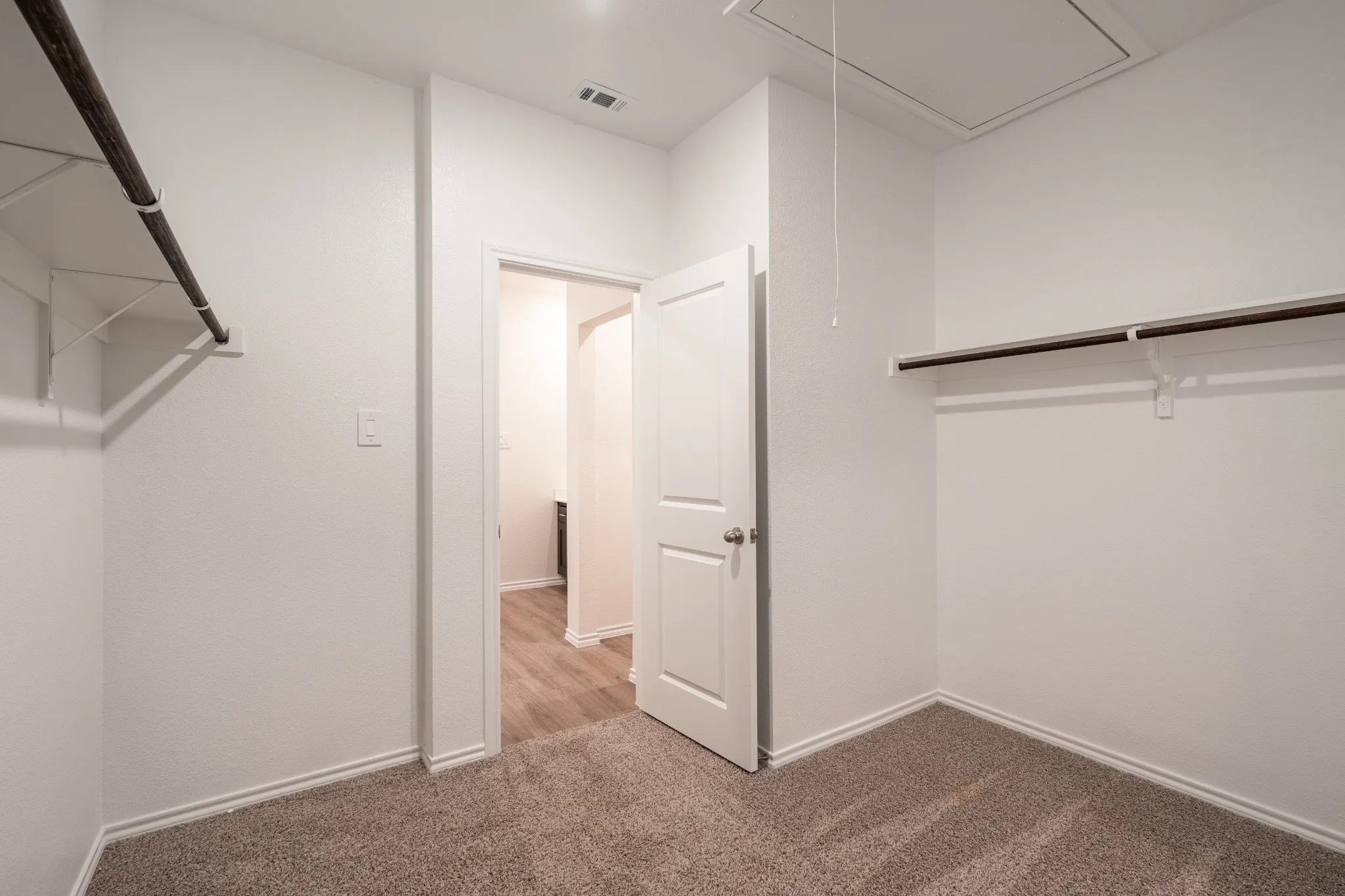 Expansive walk-in closet fearturing an additional flex storage space.