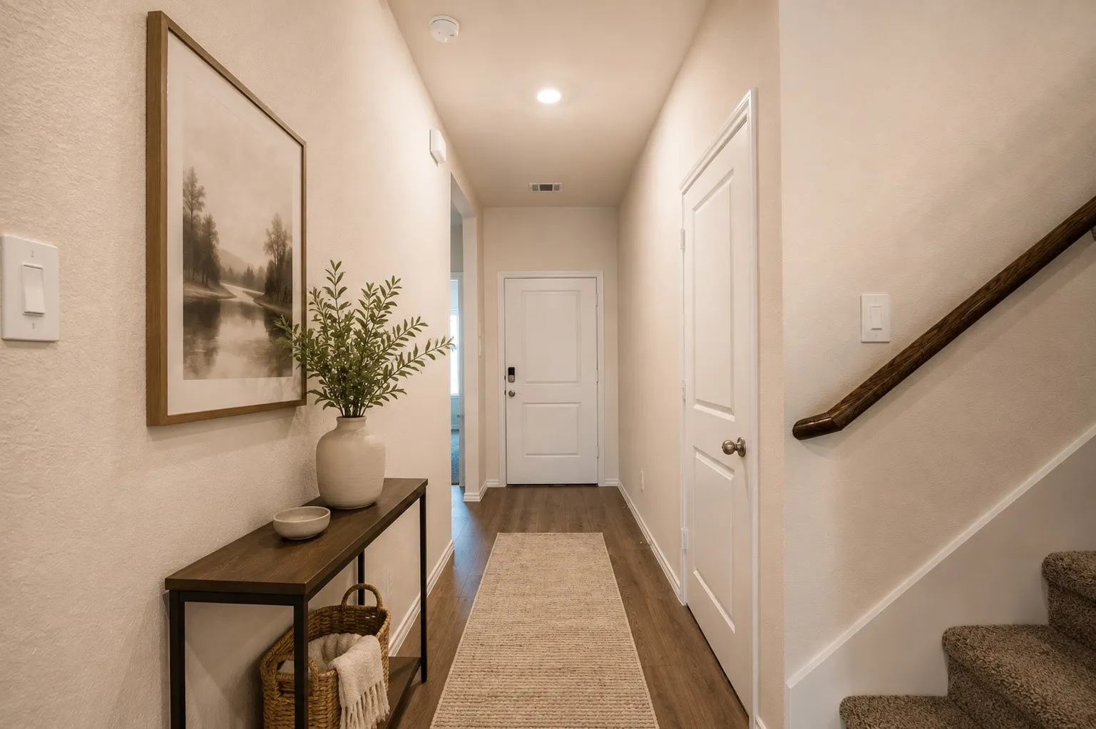 Modern entry way with a secondary bedroom to the right and flows into the gorgeous living space.
