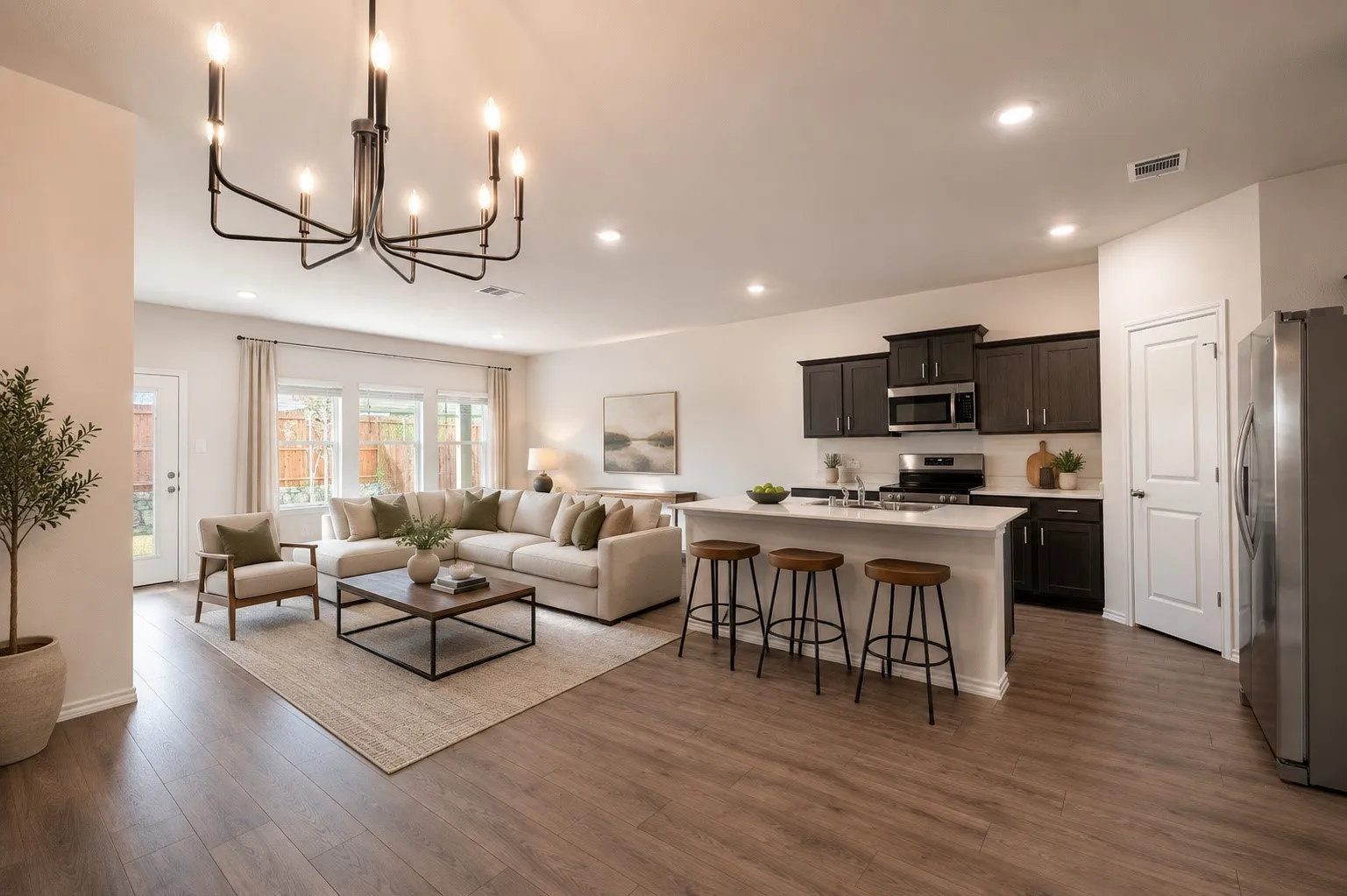 Open concept kitchen and living space overlooking the serene backyard.