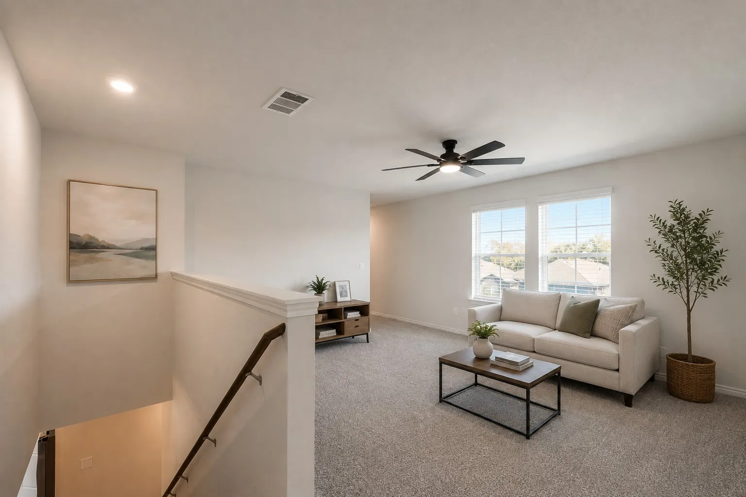 pacious game room/living space on second floor with plenty of  natural light and newly installed ceiling fan.