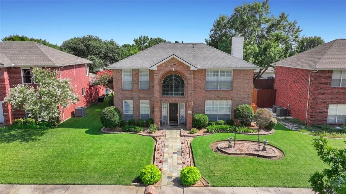 Brick exterior with a prominent arched window and a stone pathway