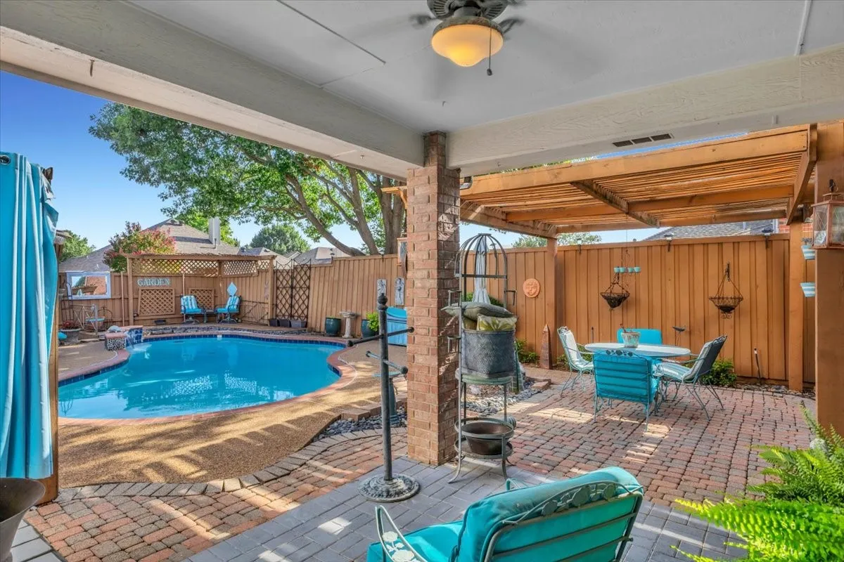 Covered patio with a ceiling fan, brick pillars, a wooden pergola, and a brick paver surface