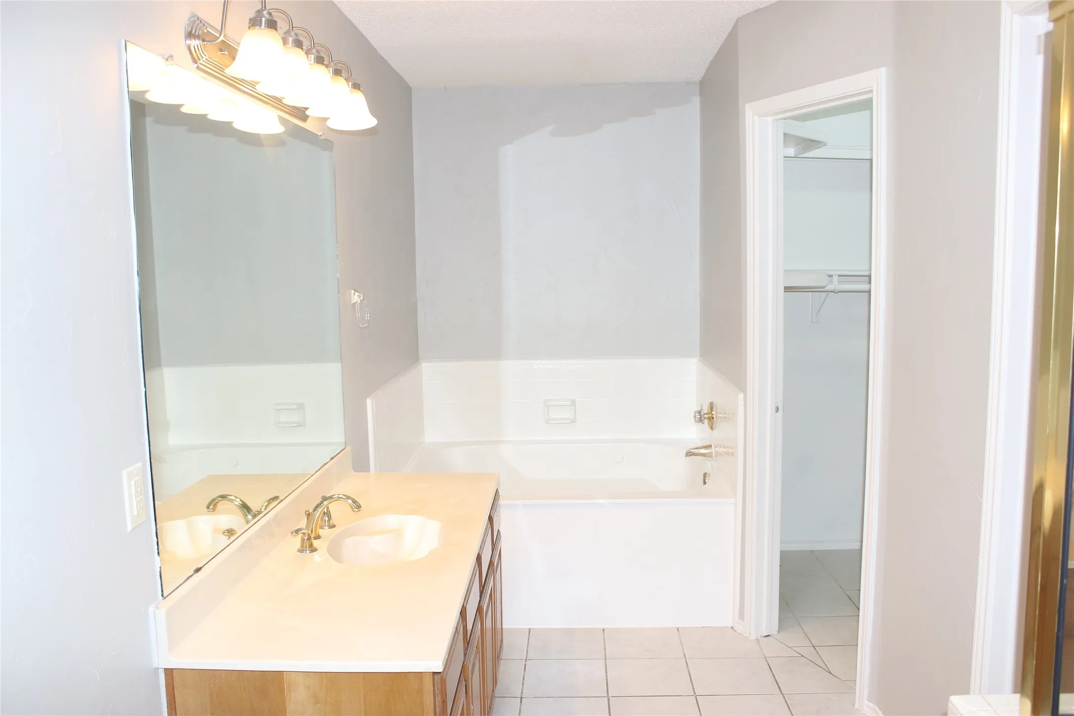 Bathroom featuring a single vanity with wood-finish cabinetry, a white countertop, and an undermount sink