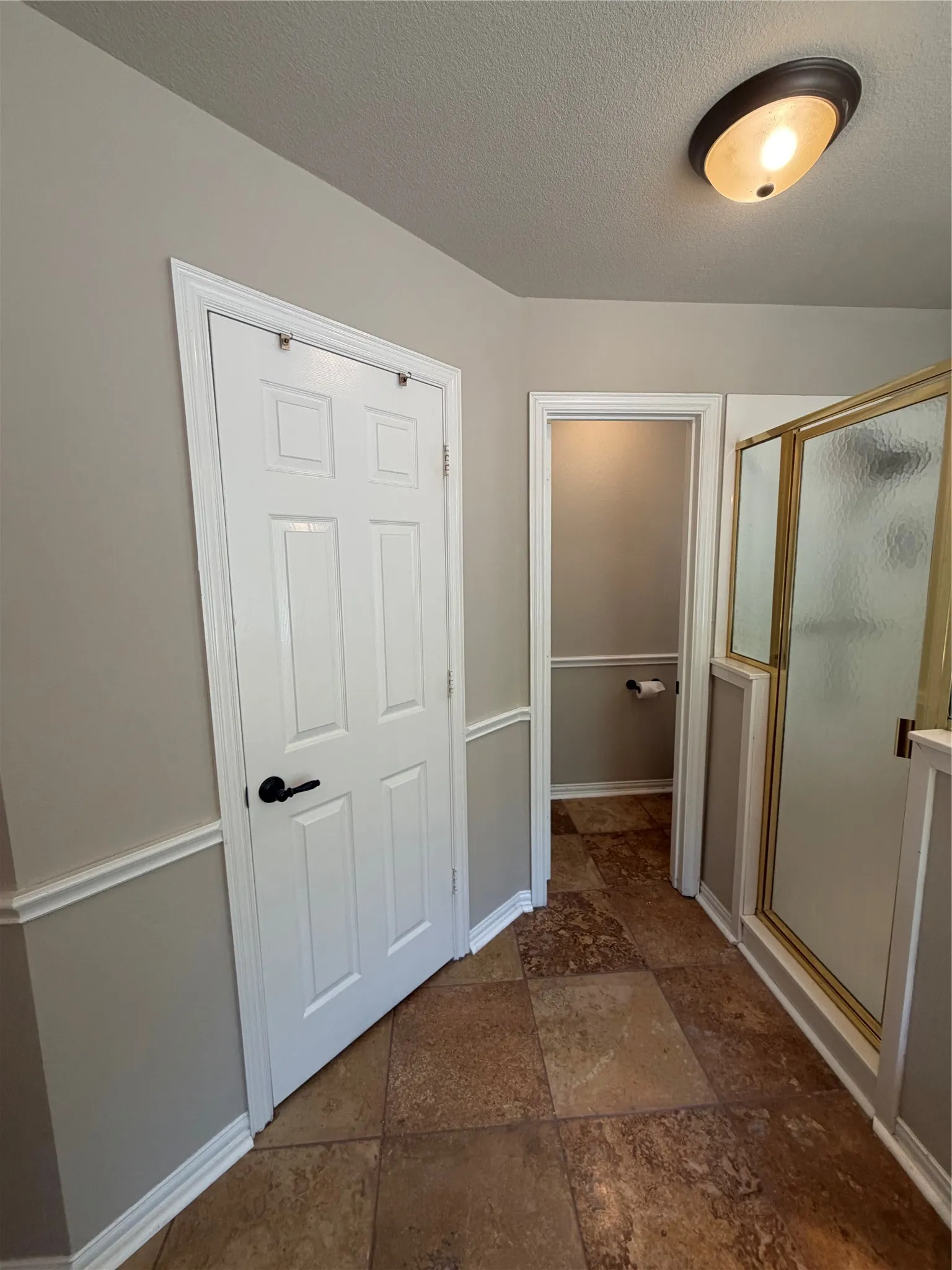 Master Bath.  Expansive tile flooring, warm wall paint, chair rail molding, and a shower enclosure with frosted glass. walk in closet.