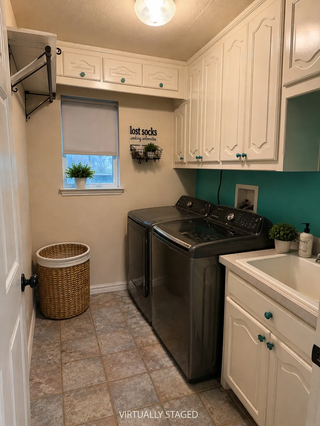 Overhead cabinetry, built-in shelving, window with roller shade, utility sink with vanity, and tile flooring