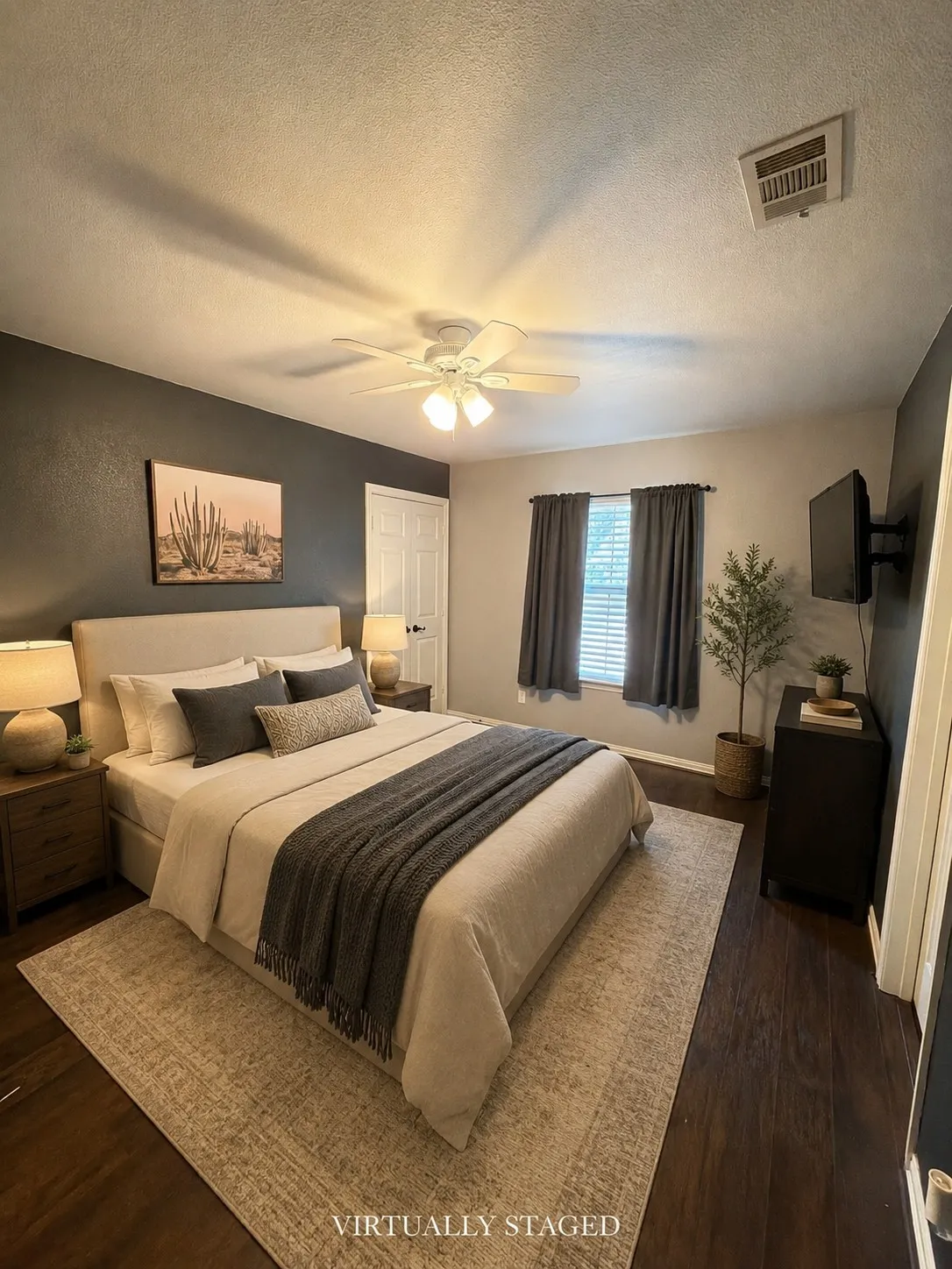 Upstairs bedroom 2. Dark wood-finish flooring, ceiling fan with integrated lighting, window with blinds, and contrasting accent wall