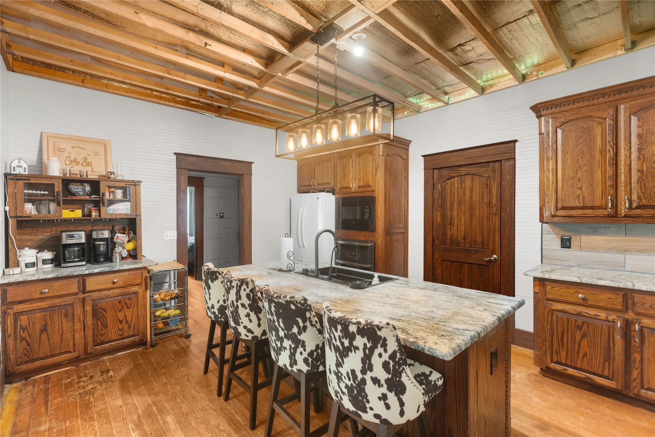 Wood flooring with custom oak cabinets, massive work island, and granite countertop