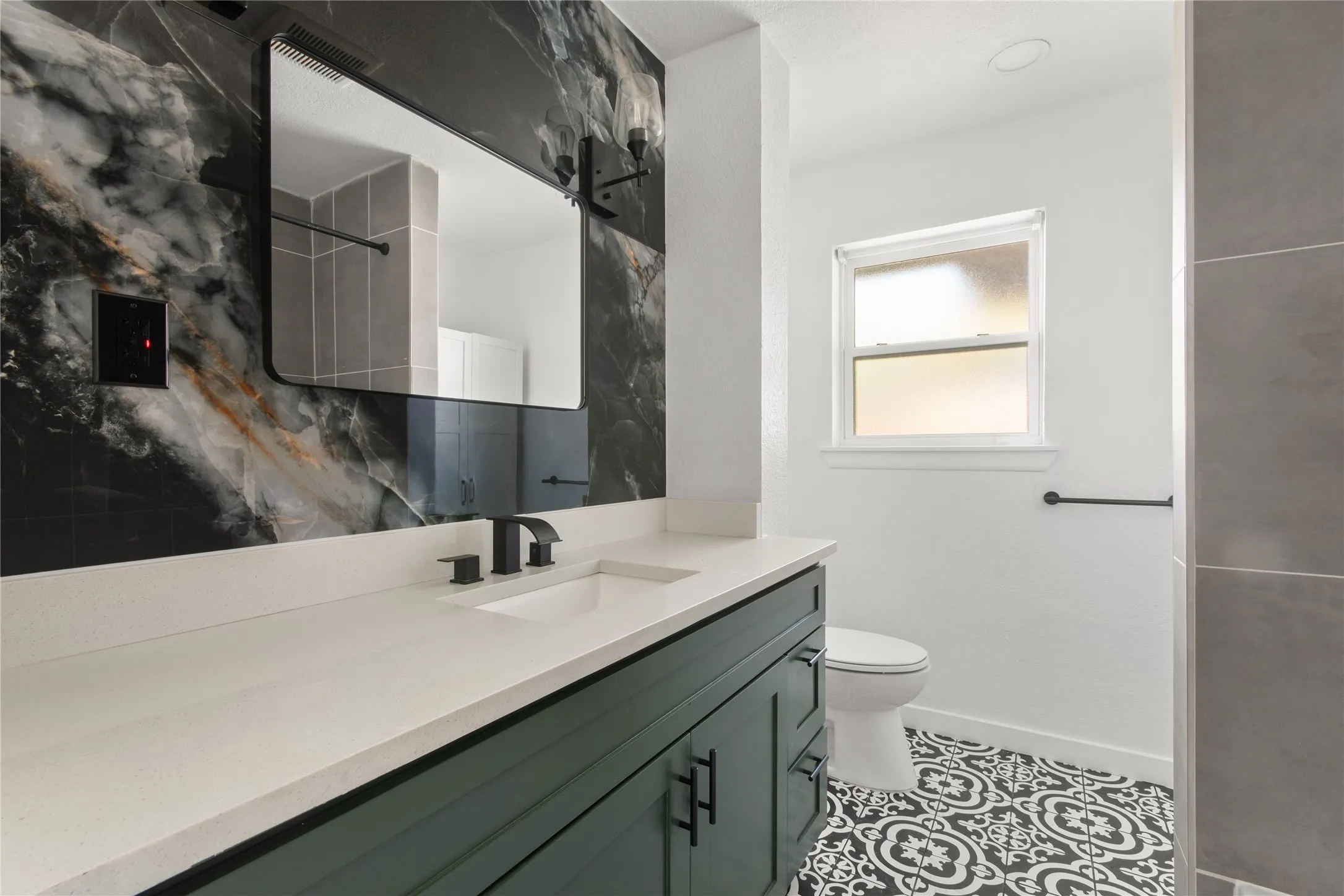 Vanity with a light-toned countertop, under-mount sink, and matte black faucet