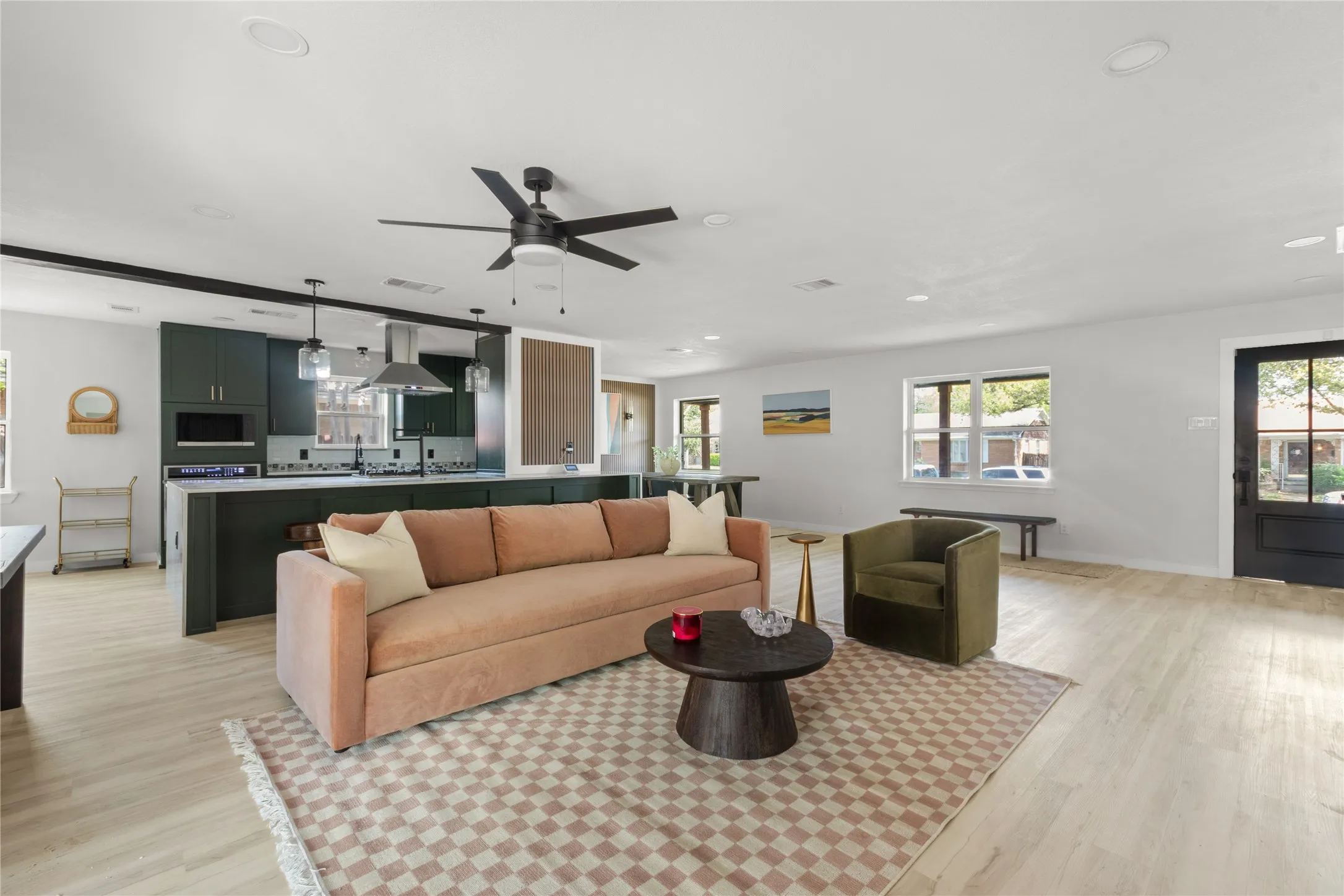 Open-concept living space with light wood-finish flooring, recessed lighting, and a contemporary ceiling fan