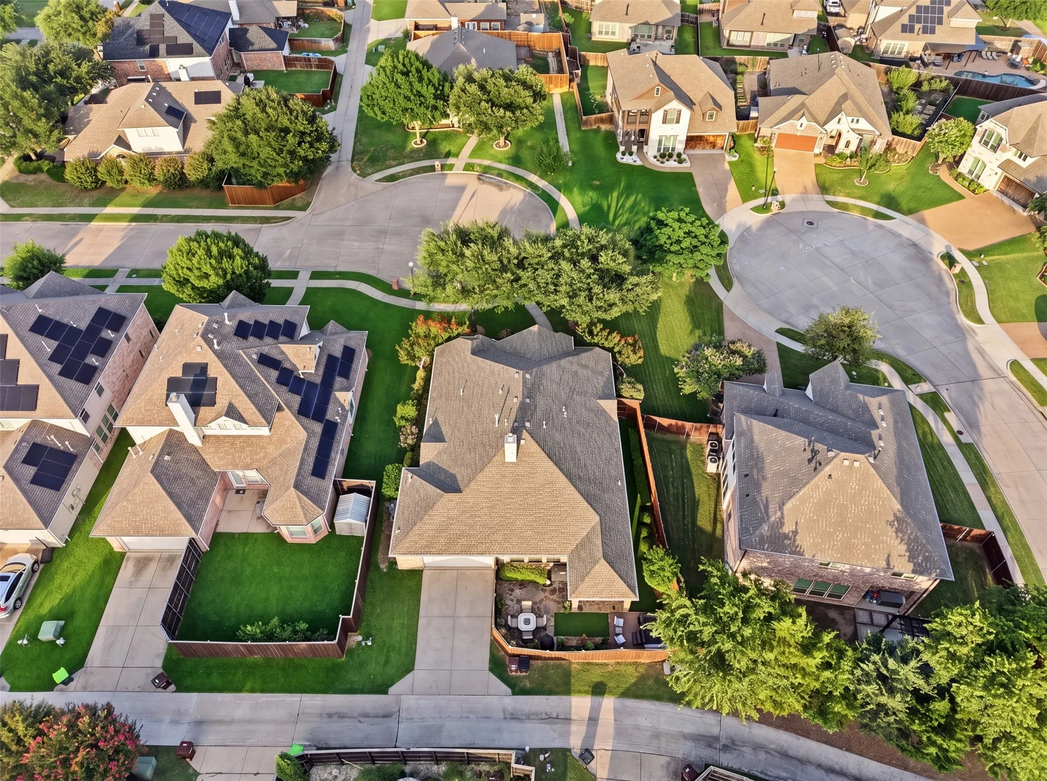 Architectural shingle roof, solar panels, and a fenced backyard with a patio