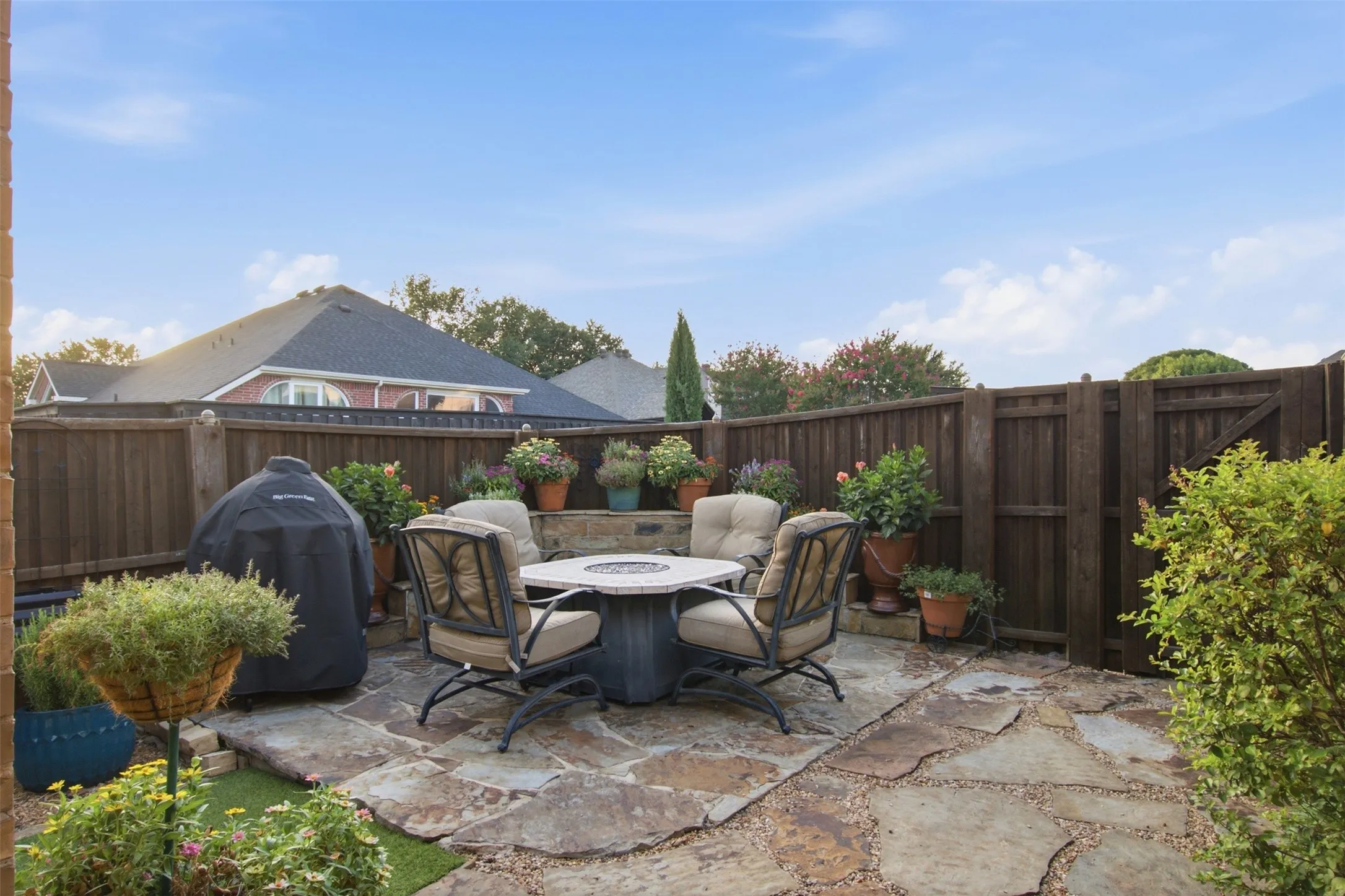 Stone patio with a wood privacy fence and built-in stone planter