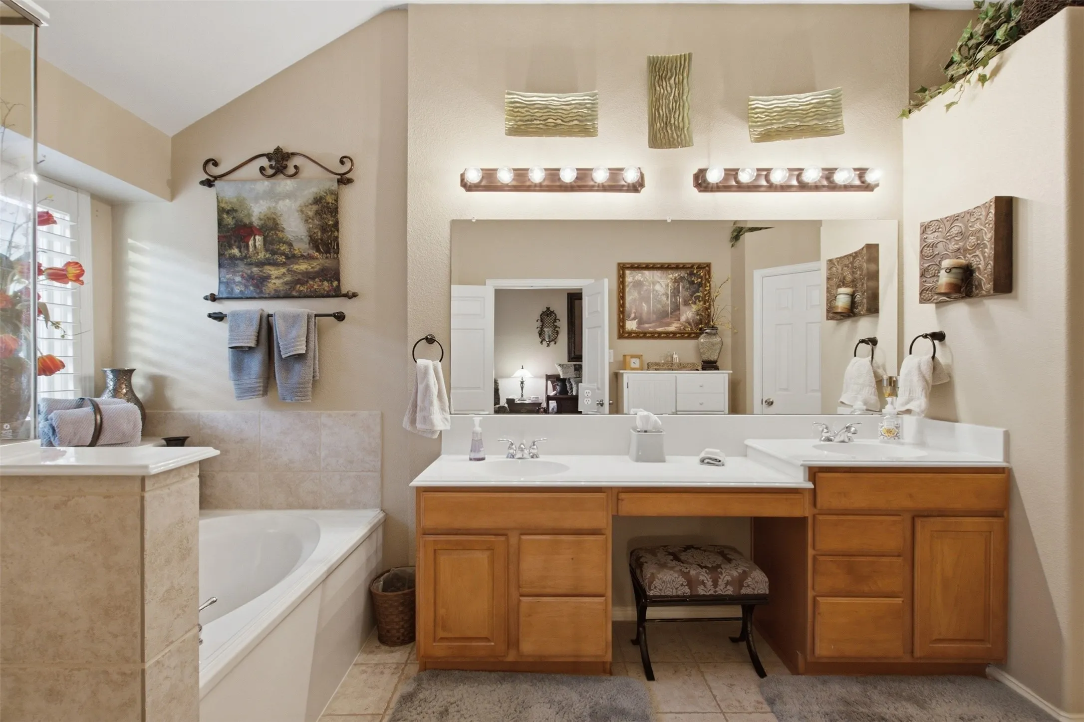 Dual vanity with integrated sinks, ample counter space, built-in cabinetry, and overhead lighting