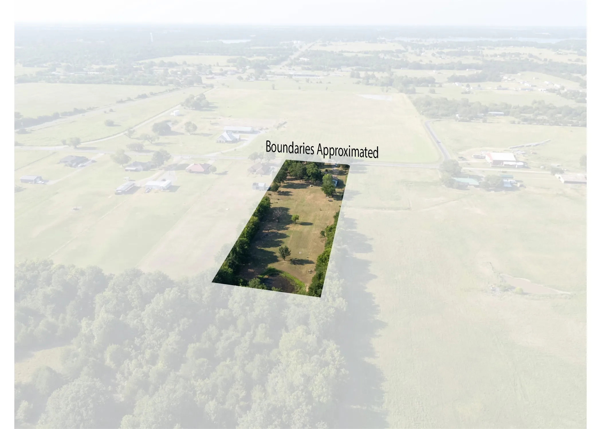Rectangular parcel with partial tree coverage, surrounded by a rural landscape