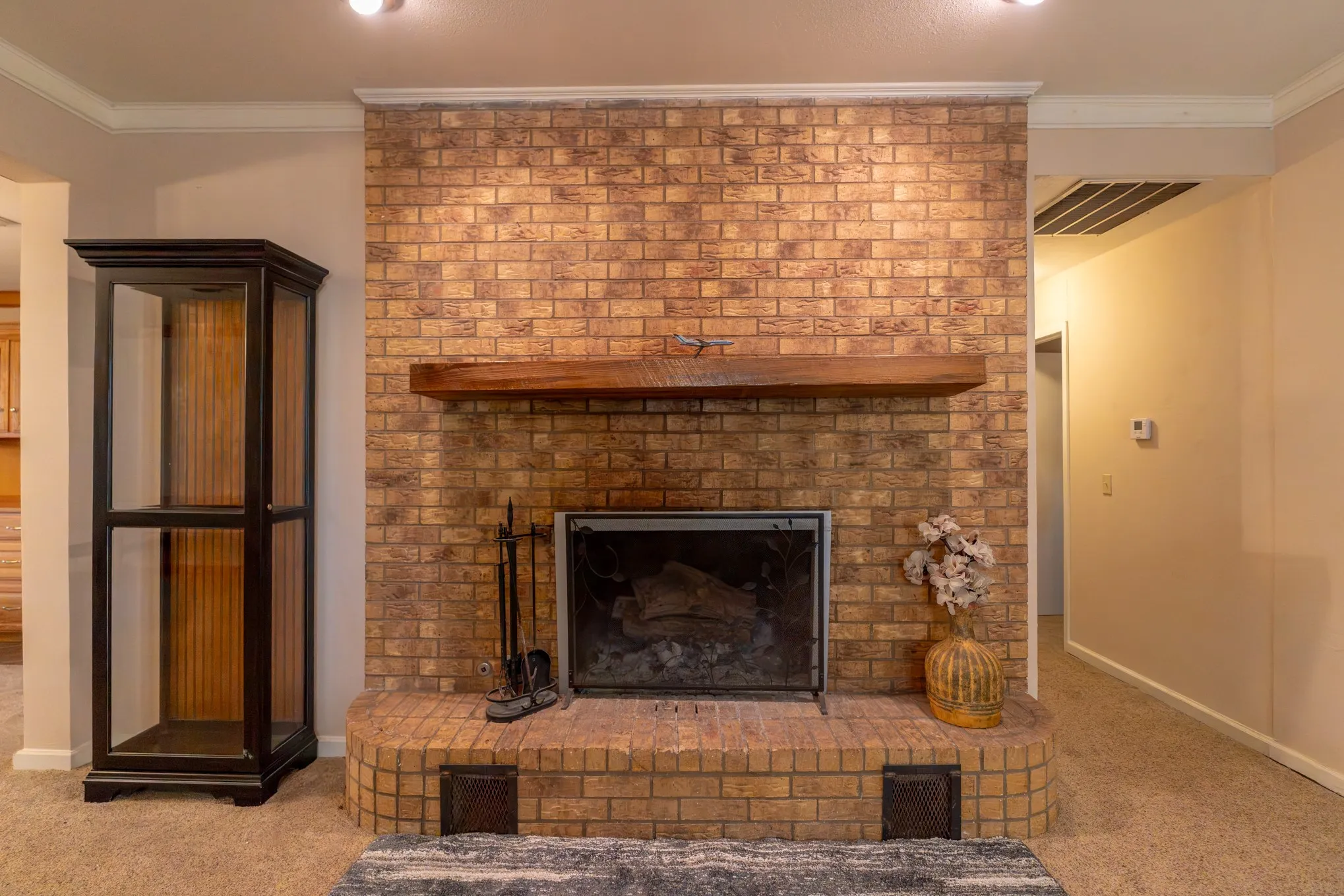 Brick fireplace with a substantial wood mantel and a hearth
