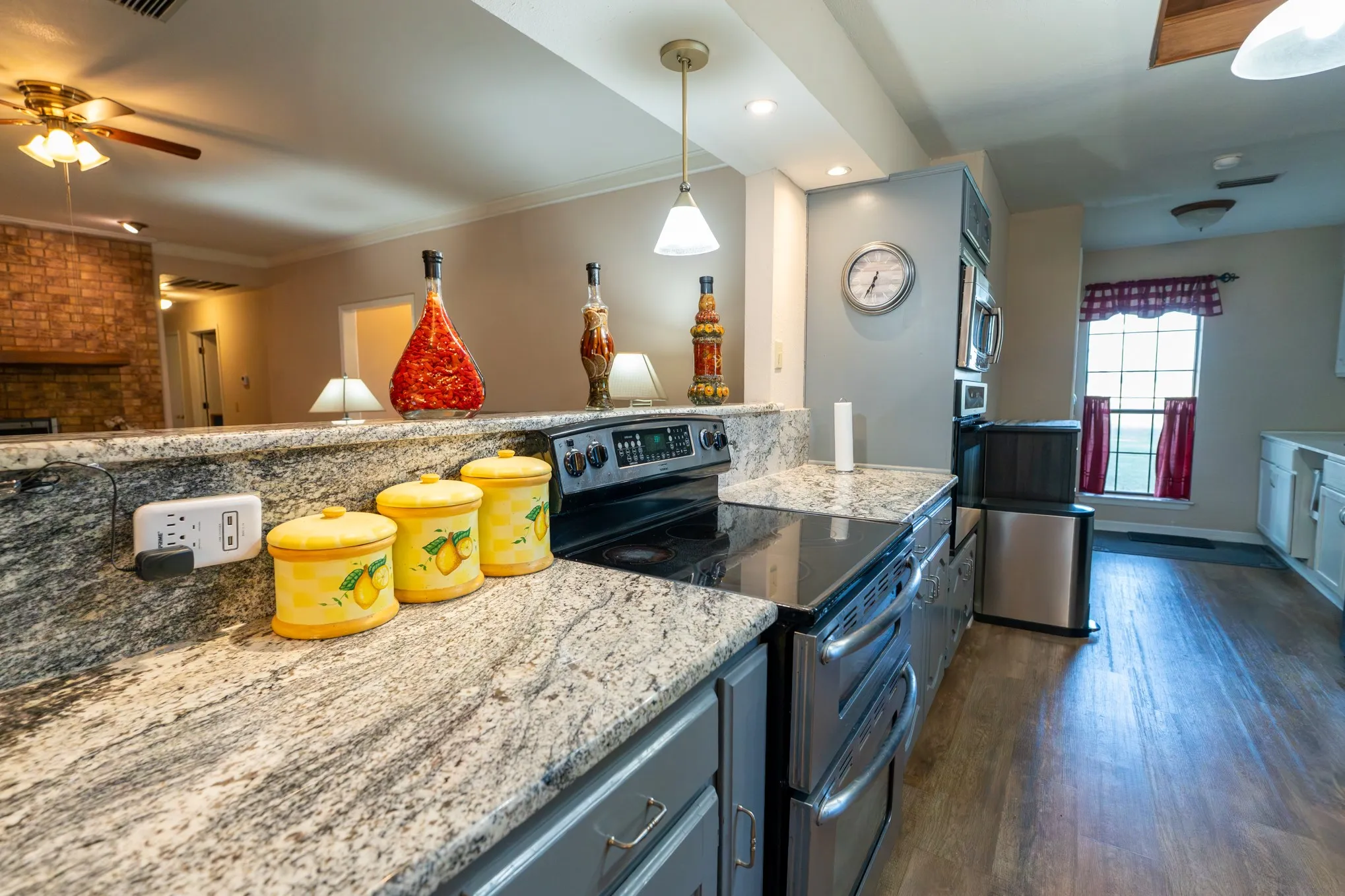 Kitchen featuring wood-finish flooring, light grey cabinetry, and granite countertops
