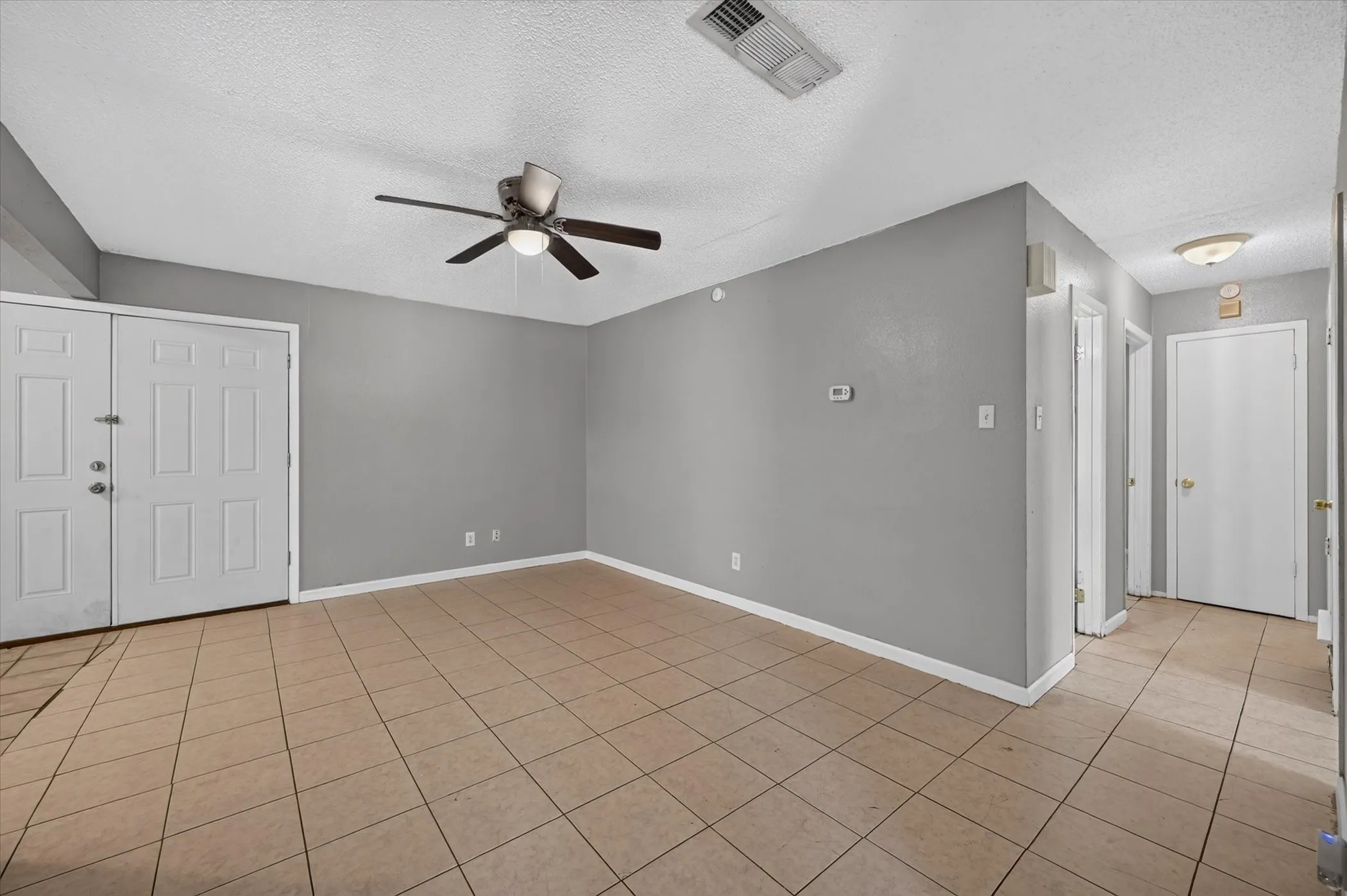 Spacious family room with durable, easy-to-maintain ceramic tile flooring.