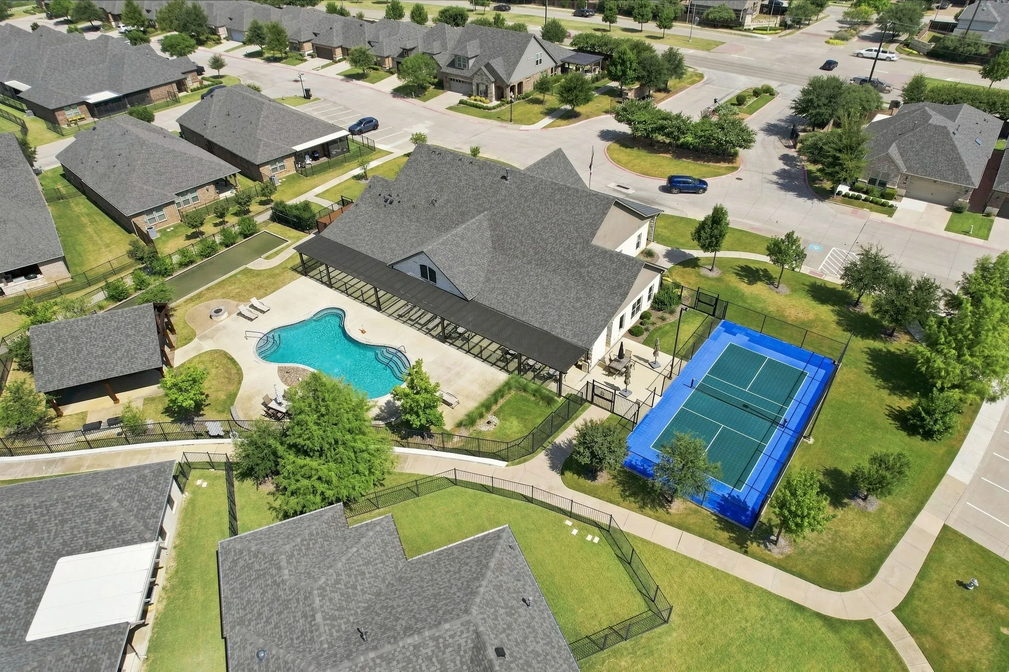 Community amenities featuring a swimming pool, shaded patio, and tennis court