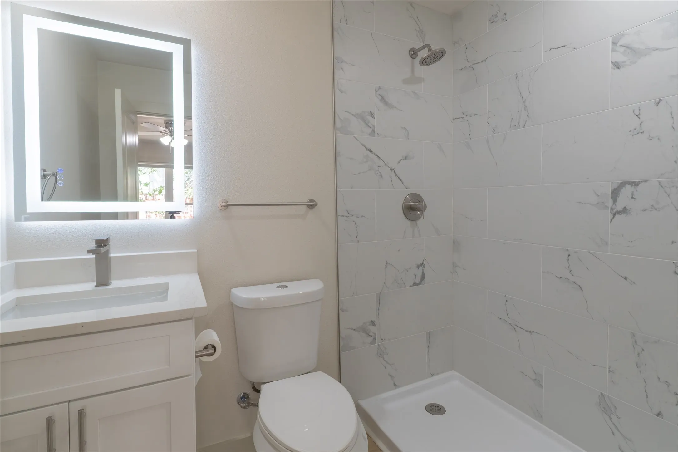 Vanity with integrated rectangular sink, illuminated mirror, and chrome faucet